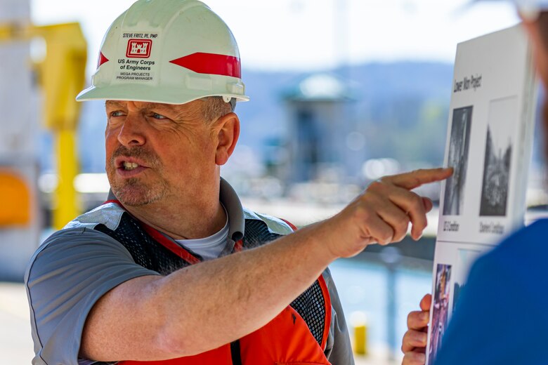 Steve Fritz, the Mega Projects program manager for the U.S. Army Corps of Engineers Pittsburgh District, briefs members of the Inland Waterways Users Board while on a tour of the Monongahela River Locks and Dam 4 at Charleroi, Pennsylvania, April 12, 2023.

The U.S. Army Corps of Engineers Pittsburgh District hosted the tour and several briefings about ongoing and future inland navigation construction projects within the district.

During the tour, Inland Waterways User Board (IWUB) members learned about the overall Lower Monongahela River navigation project and the new river chamber construction at Charleroi, which is in its final phase after nearly 20 years of construction. Members also listened to briefings about the overall Upper Ohio navigation project and its first major construction contract, the new Montgomery lock construction. 

IWUB is an industry federal-advisory committee representing all fuel-taxed inland waterway systems within the United States. The navigation industry contributes to the Inland Waterways Trust Fund through fuel taxes paid by carriers who transport bulk commodities on the inland waterway system. The board makes recommendations to Congress and the Assistant Secretary of the Army for Civil Works on how best to invest federal and trust funds dollars to keep the most cost-effective, environmentally friendly, and safest form of transportation for bulk commodities resilient and reliable.
(U.S. Army Corps of Engineers Pittsburgh District photo by Michel Sauret)