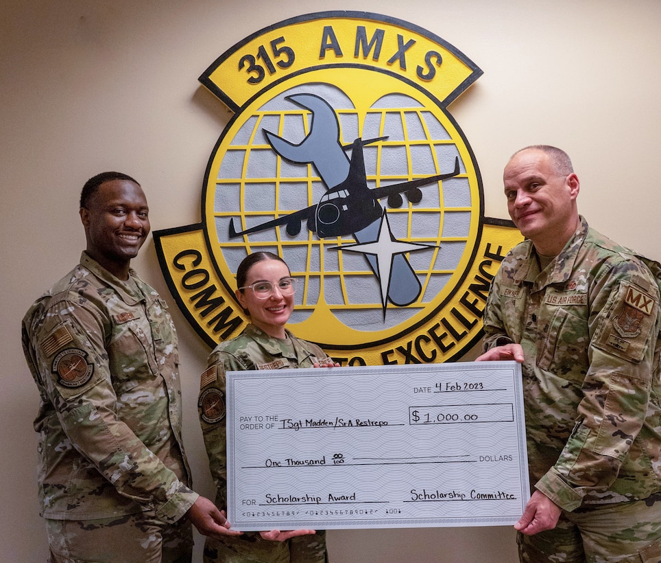 Commander of the 315th Aerospace Maintenance Squadron, Lt. Col. Terrell Eikner, delivers two $1,000 award scholarships to Senior Airman Alejandra Restrepo and Tech. Sgt. Jaylen Madden, aerospace maintainers with the 315AMXS at Joint Base Charleston, S.C.