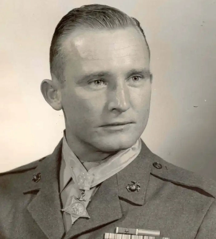 A man wearing a medal around his neck poses for a photo.