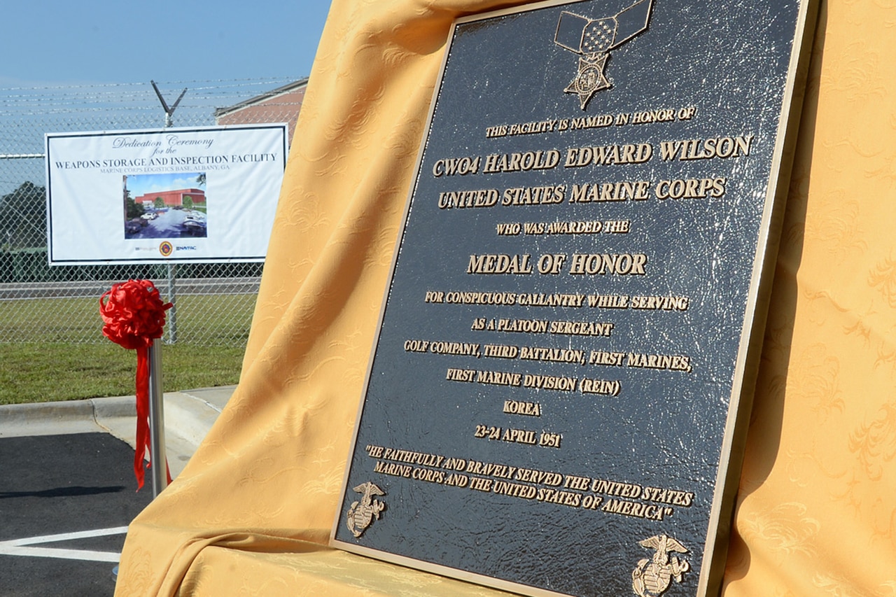 A plaque honoring a Medal of Honor recipient sits on a yellow drape.
