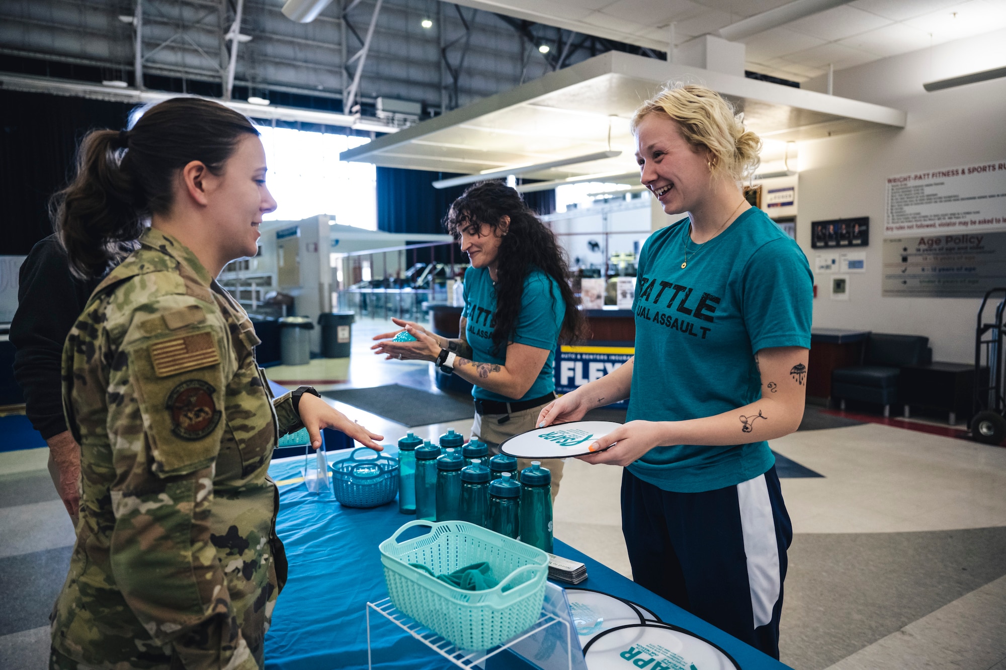 Lt. Sydney Taggart, Sexual Assault Prevention and Response volunteer victim advocate, hands out Sexual Assault Awareness and Prevention Month merchandise April 12 to a Be Fit fitness class participant at Wright-Patterson Air Force Base, Ohio.