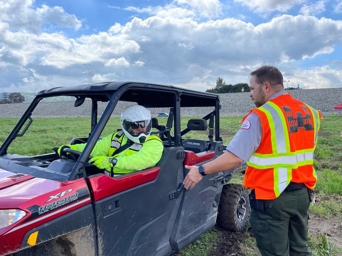 Frank Gonzalez, a member of the fence maintenance crew with the Los Angeles District’s Operations and Maintenance Branch, left, takes cues from Nicolas Figueroa, LA District park ranger, during utility terrain vehicle training March 23 at the Whittier Narrows Dam area of operations in Pico Rivera, California.