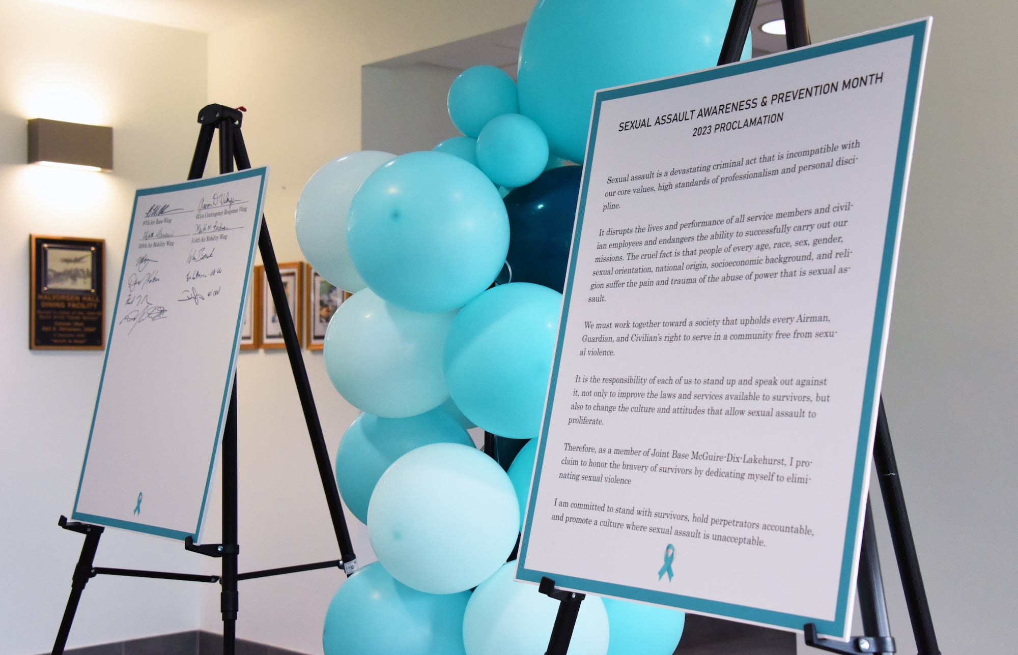 Two displays of the Sexual Assault Awareness and Prevention Month proclamations sit inside the Halvorsen Hall dining facility at the SAAPM proclamation signing on Joint Base McGuire-Dix-Lakehurst, N.J., Apr. 6, 2023. The SAAPM proclamation signing is an event that Joint Base MDL leadership and members of the joint base community come together to promote the prevention of sexual violence and provide protection and support to the victims and survivors of interpersonal violence around the joint base. April is Sexual Assault Awareness and Prevention Month. Joint Base MDL observes this month by raising awareness to prevent sexual assault and harassment and to provide resources and victim support to educate the public. These efforts contribute to a safe and secure joint base community.  (U.S. Air Force photo by Daniel Barney)
