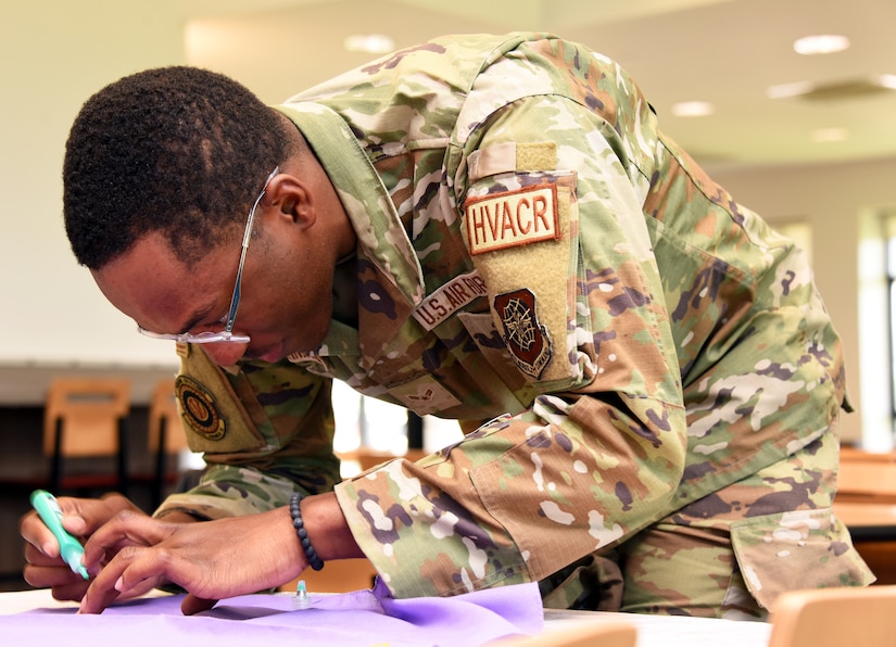 U.S. Air Force Airman 1st Class Henry Johnson-Nwakaego, 87th Civil Engineering Squadron heating, ventilation, air conditioning, and refrigeration apprentice, decorates a bandana as part of the Clothesline of Healing event on Joint Base McGuire-Dix-Lakehurst, N.J., Apr. 12, 2023. The Clothesline of Healing is an event where members of the joint base community can decorate bandanas to show support for survivors and honor victims of interpersonal violence. April is Sexual Assault Awareness and Prevention Month. Joint Base MDL observes this month by raising awareness to prevent sexual assault and harassment and to provide resources and victim support to educate the public. These efforts contribute to a safe and secure joint base community. (U.S. Air Force photo by Daniel Barney)