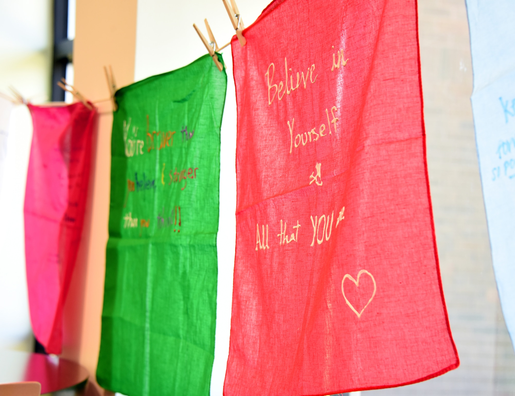 A clothesline display of decorated bandanas hanging up inside the Halvorsen Hall dining facility as part of the Clothesline of Healing event on Joint Base McGuire-Dix-Lakehurst, N.J., Apr. 12, 2023. The Clothesline of Healing is an event where members of the joint base community can decorate bandanas to show support for survivors and honor victims of interpersonal violence. April is Sexual Assault Awareness and Prevention Month. Joint Base MDL observes this month by raising awareness to prevent sexual assault and harassment and to provide resources and victim support to educate the public. These efforts contribute to a safe and secure joint base community. (U.S. Air Force photo by Daniel Barney)