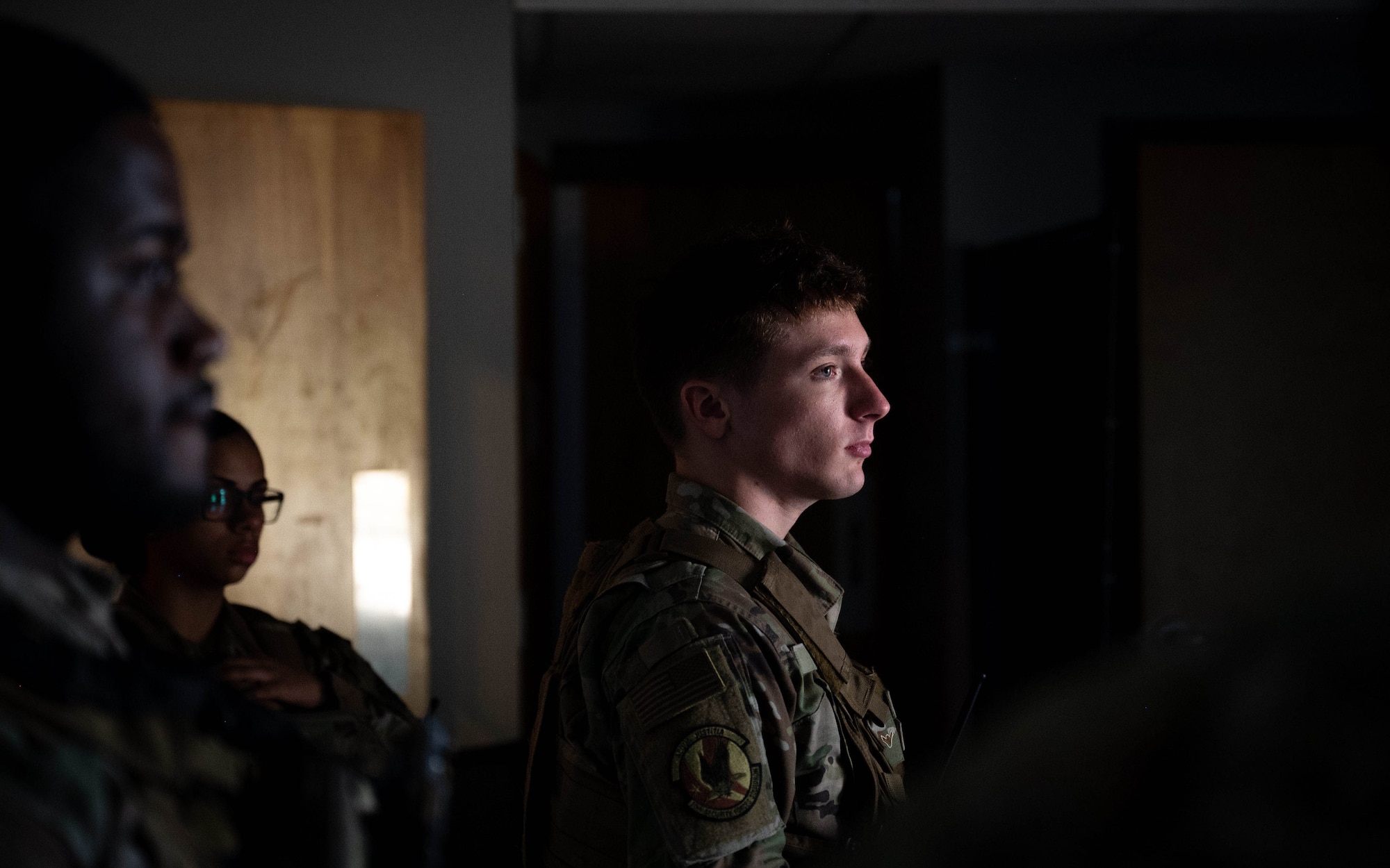 Airman receives instructions in a dark, closed room