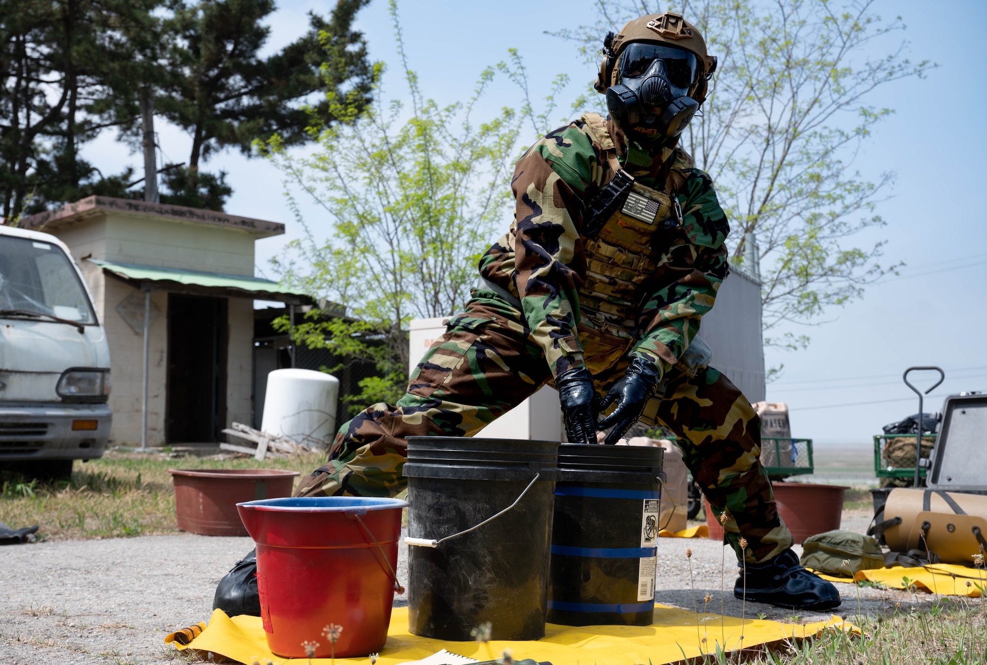 Senior Airman Charles James, 8th Civil Engineer Squadron explosive ordnance disposal technician, sanitizes his gloves during a training event at Kunsan Air Base, Republic of Korea, April 20, 2023. The EOD team members were tested on their ability to operate in a hazardous environment while wearing Mission Oriented Protective Posture gear. (U.S. Air Force photo illustration by Senior Airman Shannon Braaten)