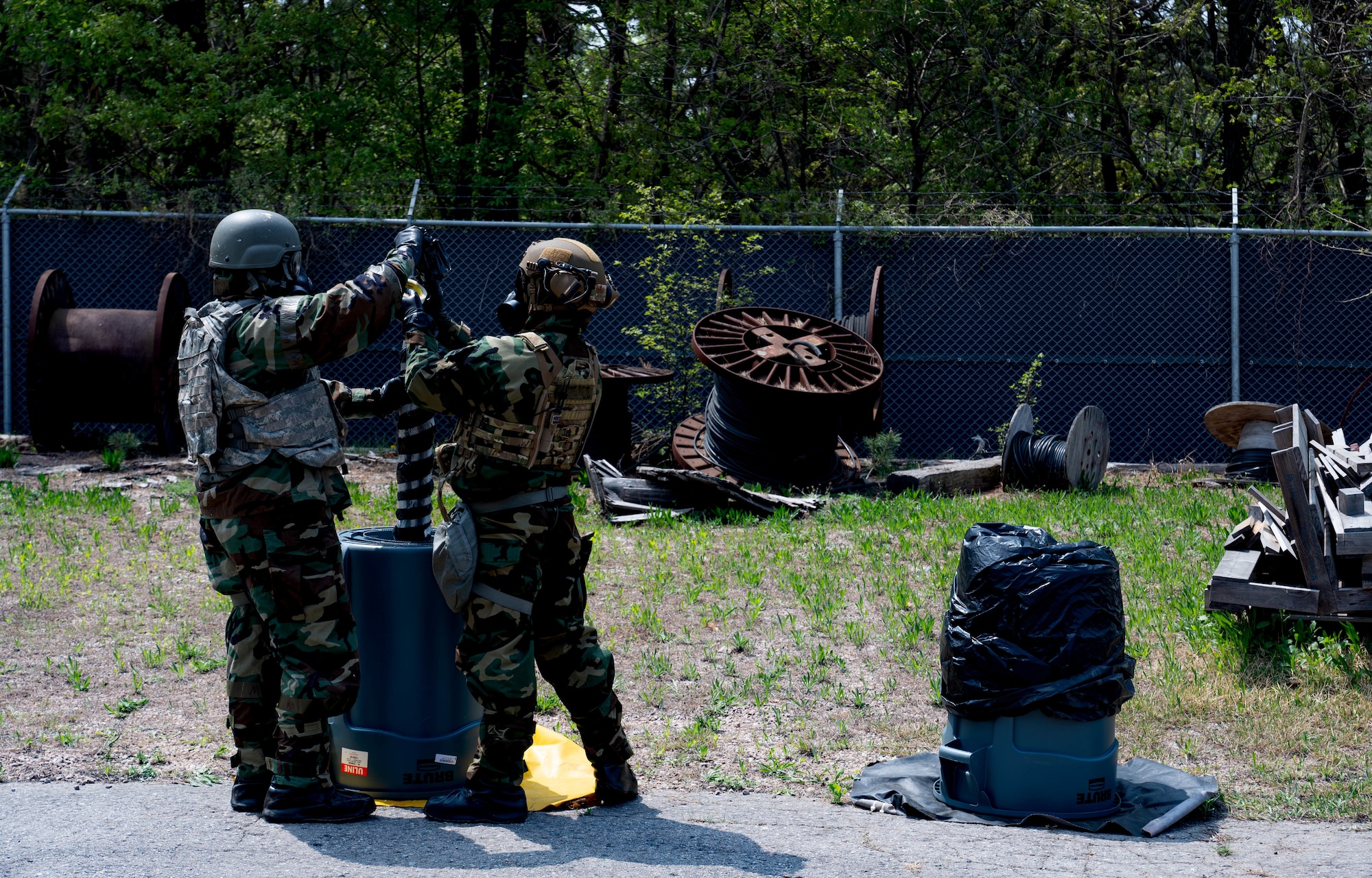 Airmen from the 8th Civil Engineer Squadron explosive ordnance disposal flight, secures a simulated chemical ordnance at Kunsan Air Base, Republic of Korea, April 20, 2023.  EOD team members were tested on their ability to operate in a hazardous environment while mitigating hazards from leaking chemical munitions. (U.S. Air Force photo illustration by Senior Airman Shannon Braaten)