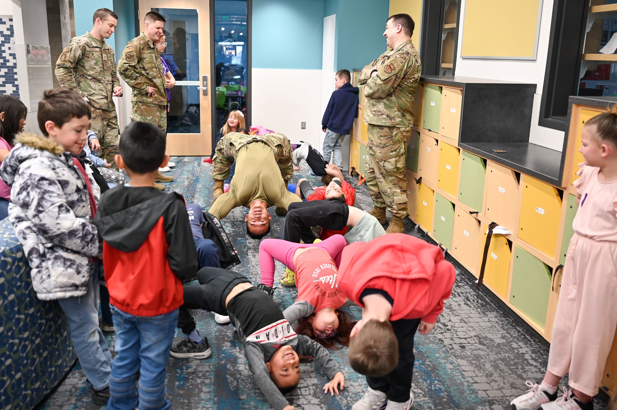 Technical Sgt. Justin Southichack, 367th Training Support Squadron, backbends with South Clearfield Elementary students April 18, 2023, in Clearfield, Utah. The Airmen visited the school to engage with the community during the Month of the Military Child. (U.S. Air Force photo by Cynthia Griggs)