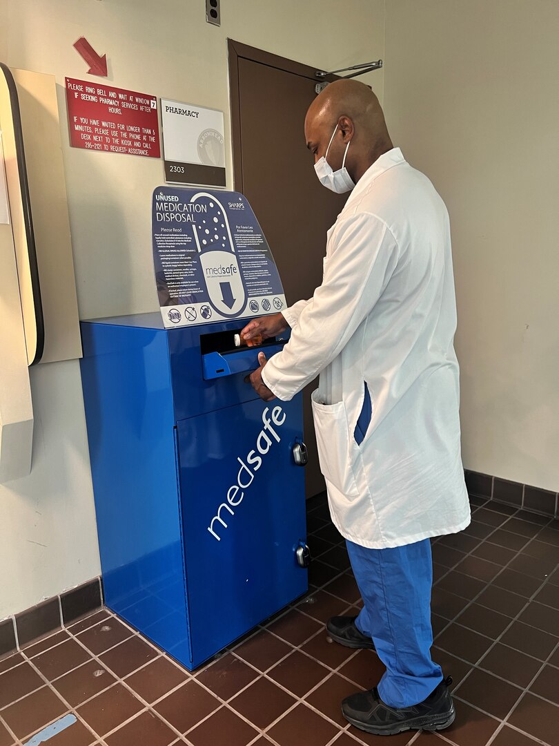 Person demonstrating throwing unused medication in MedSafe bin.