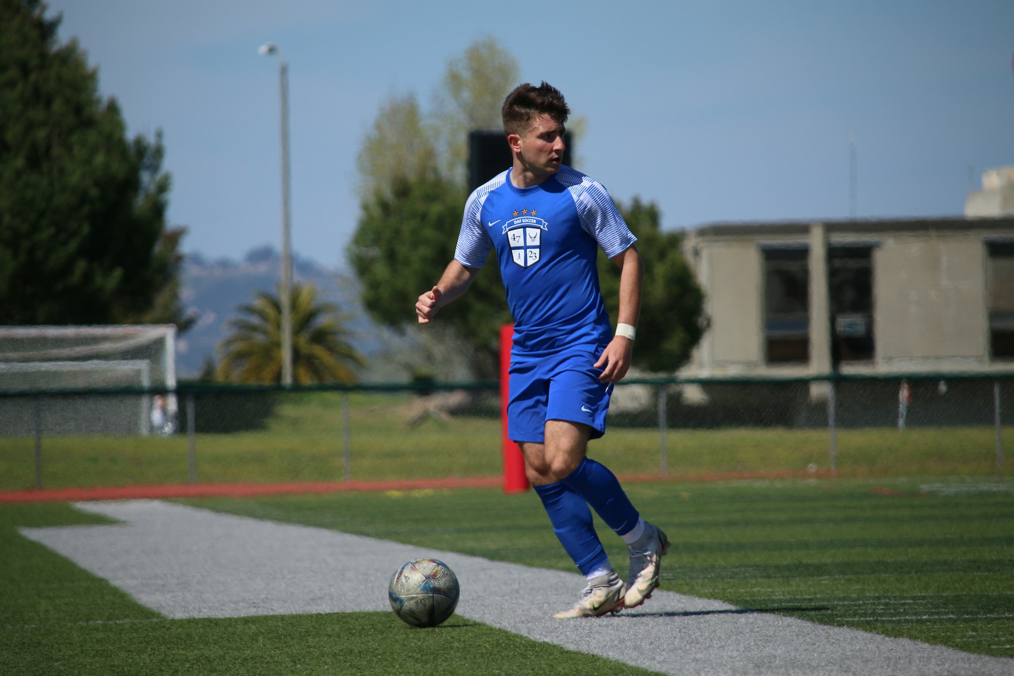 player in blue uniform plays the ball