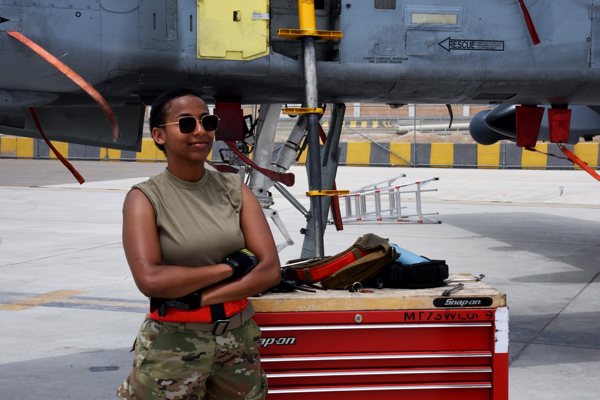 U.S Air Force Airman First Class Fasika Robinson, 75th Expeditionary Fighter Generation Squadron weapons loader, stands next to her toolbox waiting to load 30mm rounds into an A-10 Thunderbolt II in preparation for the first live-fire sortie out of Al Dhafra Air Base, United Arab Emirates, April 18, 2023. The deployment of A-10s in the region provides additional capability in the Middle East alongside fighter aircraft. Ninth Air Force (U.S. Air Forces Central) is committed to ensuring security and stability alongside our partners in the U.S. Central Command area of responsibility. (U.S. Air Force photo by Tech. Sgt. Chris Jacobs/released)