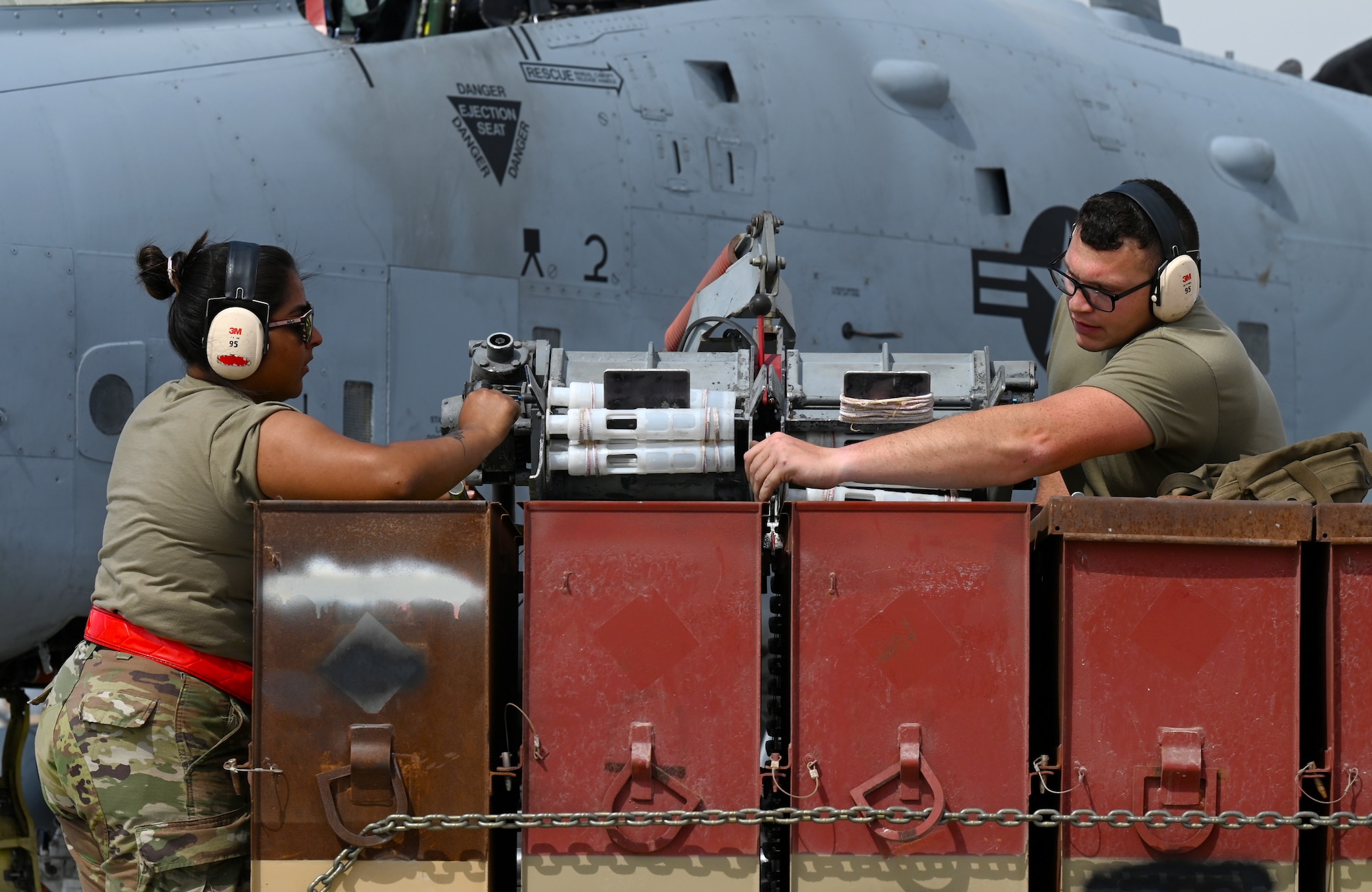 U.S. Air Force Airman 1st Class Serena Mena, 75th Expeditionary Fighter Generation Squadron weapons load crew member, and Senior Airman Nickolus Huscha, 74th Expeditionary Fighter Generation Squadron weapons load crew member, maneuvers an ammunition loader in place to load rounds into a U.S. Air Force A-10 Thunderbolt II at Al Dhafra Air Base, United Arab Emirates, April 18, 2022. The deployment of A-10s in the region provides additional capability in the Middle East alongside fighter aircraft. Ninth Air Force (U.S. Air Forces Central) is committed to ensuring security and stability alongside our partners in the U.S. Central Command area of responsibility.  (U.S. Air Force photo by Tech. Sgt. Alex Fox Echols III)