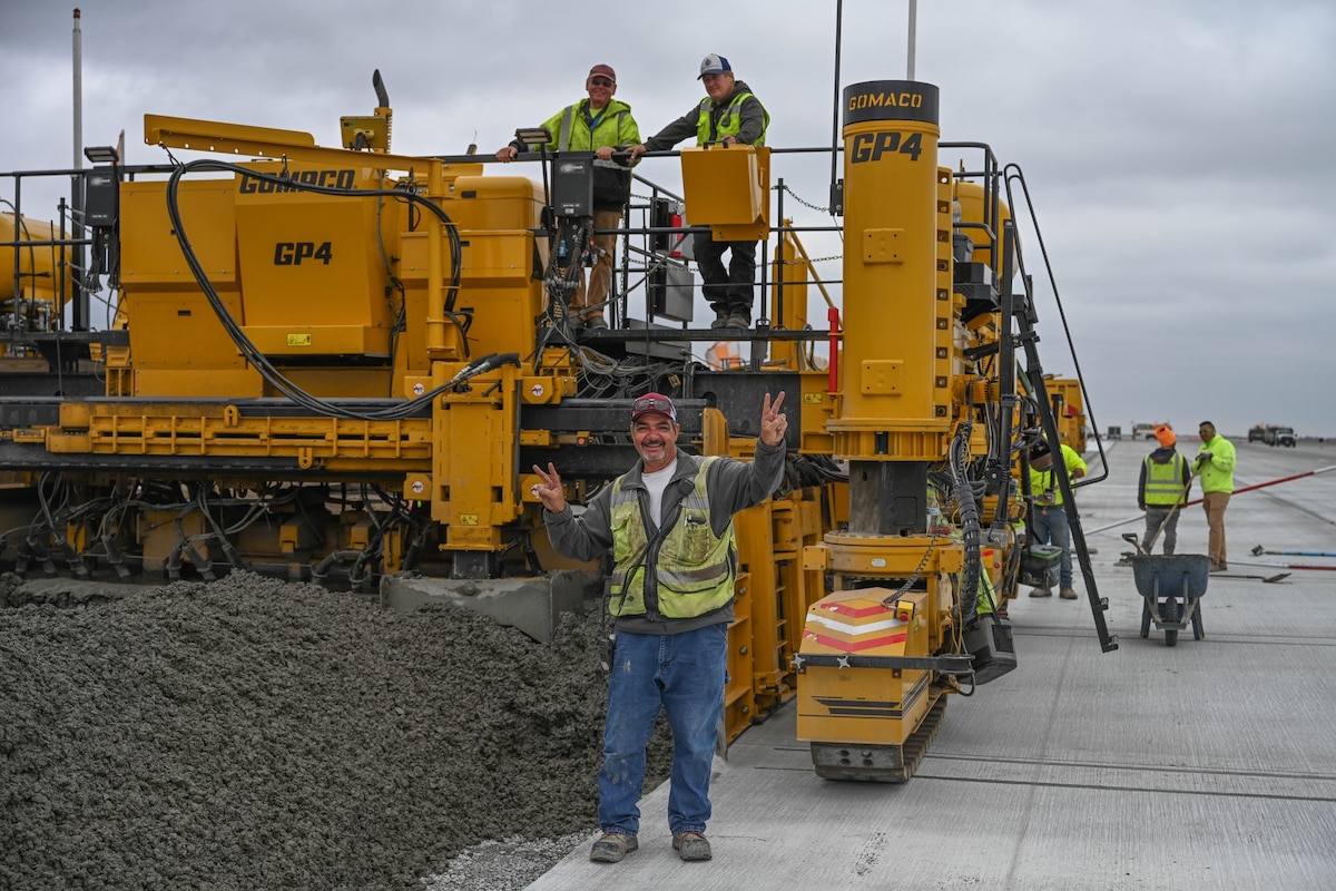 Man smiling in front of equipment and other people
