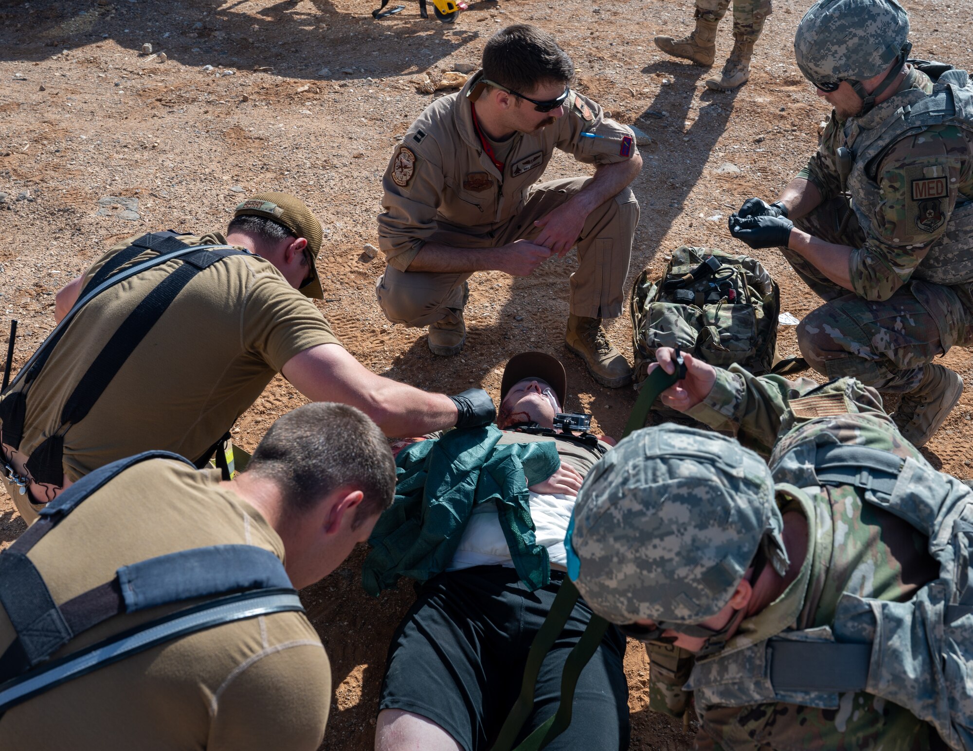 U.S. Air Force Airmen from the 332d Expeditionary Medical Squadron and 332d Civil Engineer Squadron apply tactical combat casualty care skills to a simulated injured patient at an undisclosed location in Southwest Asia March 13, 2023.