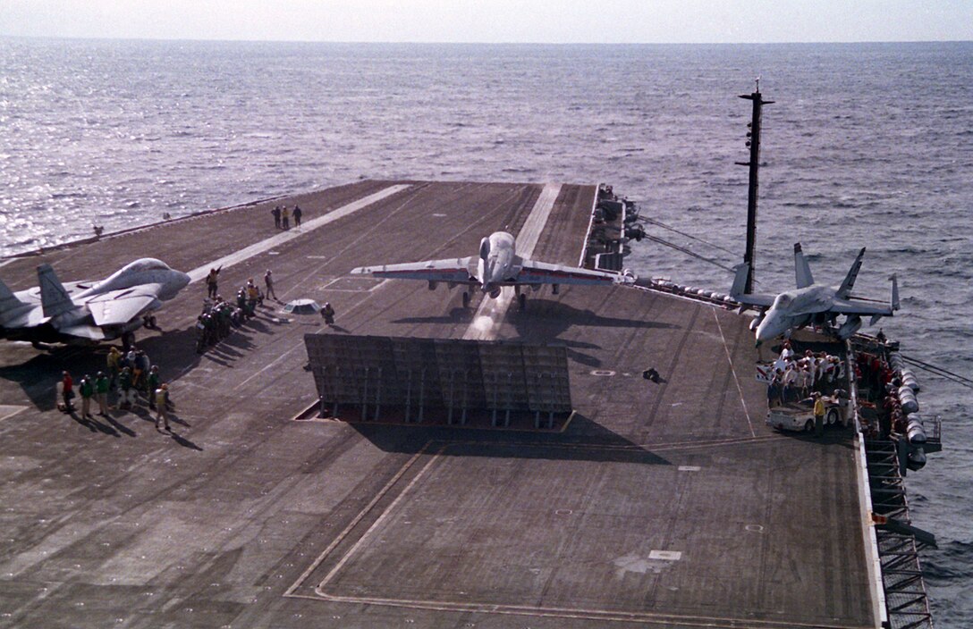 An EA-6B Prowler aircraft of Tactical Electronic Warfare Squadron 130 (VAQ-130) streaks off the deck of nuclear-powered aircraft carrier USS Dwight D. Eisenhower (CVN-69) during fleet carrier qualifications off the east coast, ca. February 1994. Lt. Shannon Workman, the first female pilot to qualify onboard an operational warship after the repeal of combat exclusion, piloted the aircraft. Image courtesy National Archives and Records Administration (DN-SC-94-02358).