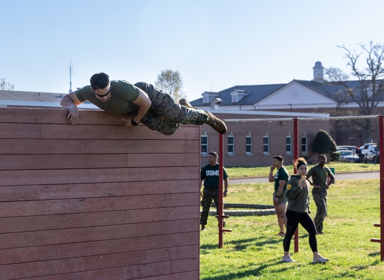 U.S. Marine Corps Staff Sgt. John E. Schmitt, an instructor with School of Infantry East, Camp Lejeune, North Carolina, jumps over a wall on an obstacle course during the “Kim’s challenge” event while participating in the first Training Education Command Fittest Instructor Competition at the Officer Candidate School on Marine Corps Base Quantico, Virginia, April 13, 2023. Marines were tested both mentally and physically by having to complete an obstacle course and a three-mile run followed by an object memorization test. (U.S. Marine Corps Photo by Lance Cpl. Kayla LeClaire)