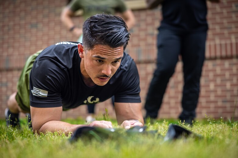 U.S. Marine Corps Staff Sgt. John Schmitt, a combat instructor with the School of Infantry-East Combat Instructor School, holds a plank during the “Prevention” event while participating in the first Training and Education Command Fittest Instructor Competition on Marine Corps Base Quantico, Virginia, April 14, 2023. Marines had nine minutes to complete as many repetitions as possible of thrusters and wall walks. (U.S. Marine Corps photo by Lance Cpl. Joaquin Dela Torre)