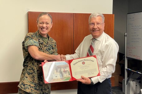 BGen Maura Hennigan, President of Marine Corps University, presents Jeffrey Moravetz from Marine Corps University Press with the Civilian of the Quarter Award on April 11, 2023.