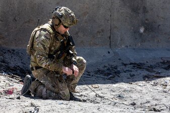 A U.S. Navy explosive ordnance disposal technician from Explosive Ordnance Disposal Mobile Unit 6 (EODMU 6) attaches a detonation cord to a blast charge during an airfield demolition and repair (ADR) drill at Joint Expeditionary Base Little Creek-Fort Story, April 18.