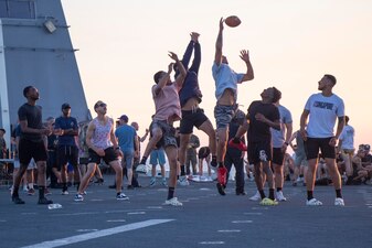 Sailors and Marines assigned to 13th Marine Expeditionary Unit play football during a steel beach picnic on the flight deck of the amphibious transport dock USS Anchorage (LPD 23), April 20.