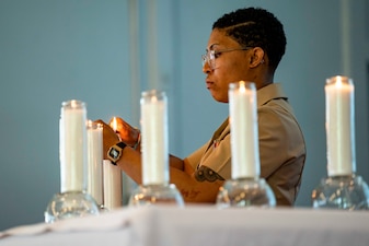 Aviation Boatswain’s Mate (Fuel) 2nd Class Jasmine Lee lights a candle during a Days of Remembrance ceremony at the Naval Support Activity Hampton Roads base chapel, April 20.