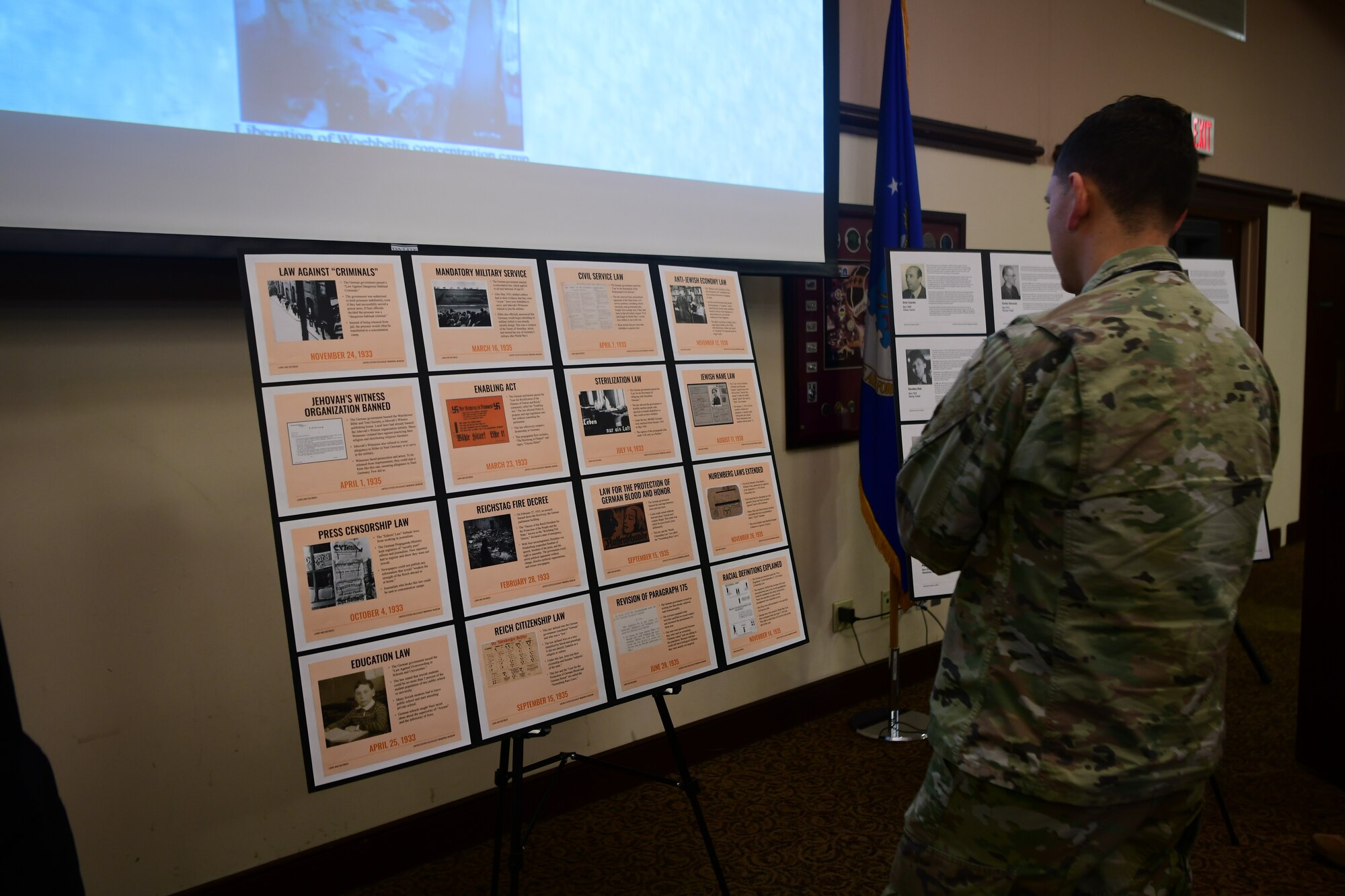 An Airman looks at a poster during the Holocaust Remembrance event at the Recce Point Club on Beale Air Force Base, California, on April 18, 2023.