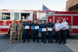 Life Saving and Significant Achievement Award recipients pose for a photo with leaders from the 11th Wing and Naval District Washington Fire and Emergency Services at the Life Saving Award presentation, April 13, 2023, Joint Base Anacostia-Bolling, Washington, D.C. Members of NDWFES were recognized with Certificates of Life Saving and Significant Achievement for their quick response to an incident on JBAB which resulted in the patient’s second chance at life. (U.S. Air Force photo by Kristen Wong)