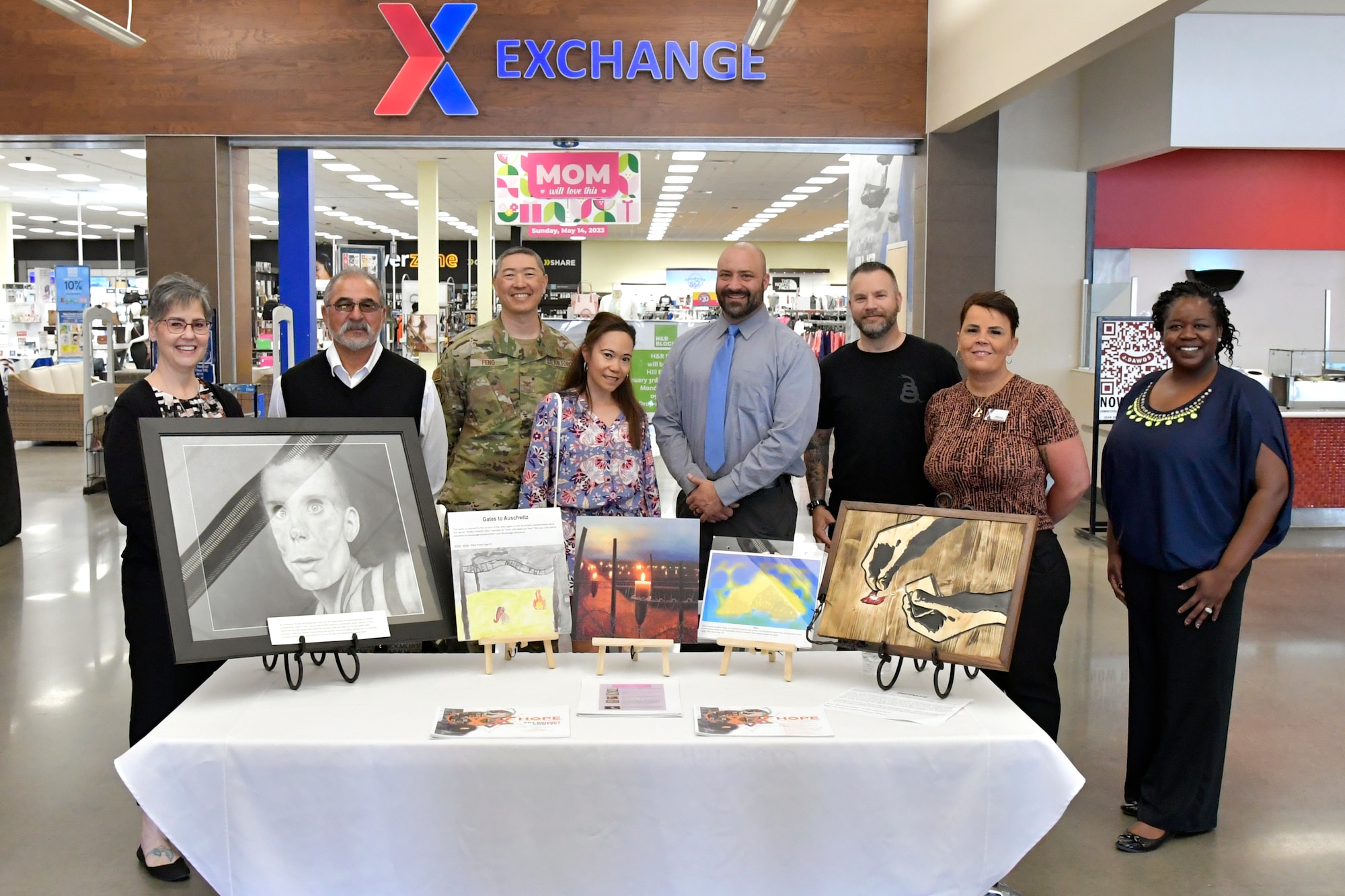 Left to right, Tammy Hairston, Utah AAFES Exchange general manager, Col. Peter Feng, 75th Air Base Wing vice commander, Carmen Feng, spouse of Col. Feng, Matt Posey, Air Force Nuclear Weapons Center, Christopher Marks, Air Force Test Center, Bianca Williams, AAFES Exchange services business manager, and Teeshia McRoberts, 75th Air Base Wing affirmative employment program manager, with the Holocaust Days of Remembrance art exhibit April 17, 2023