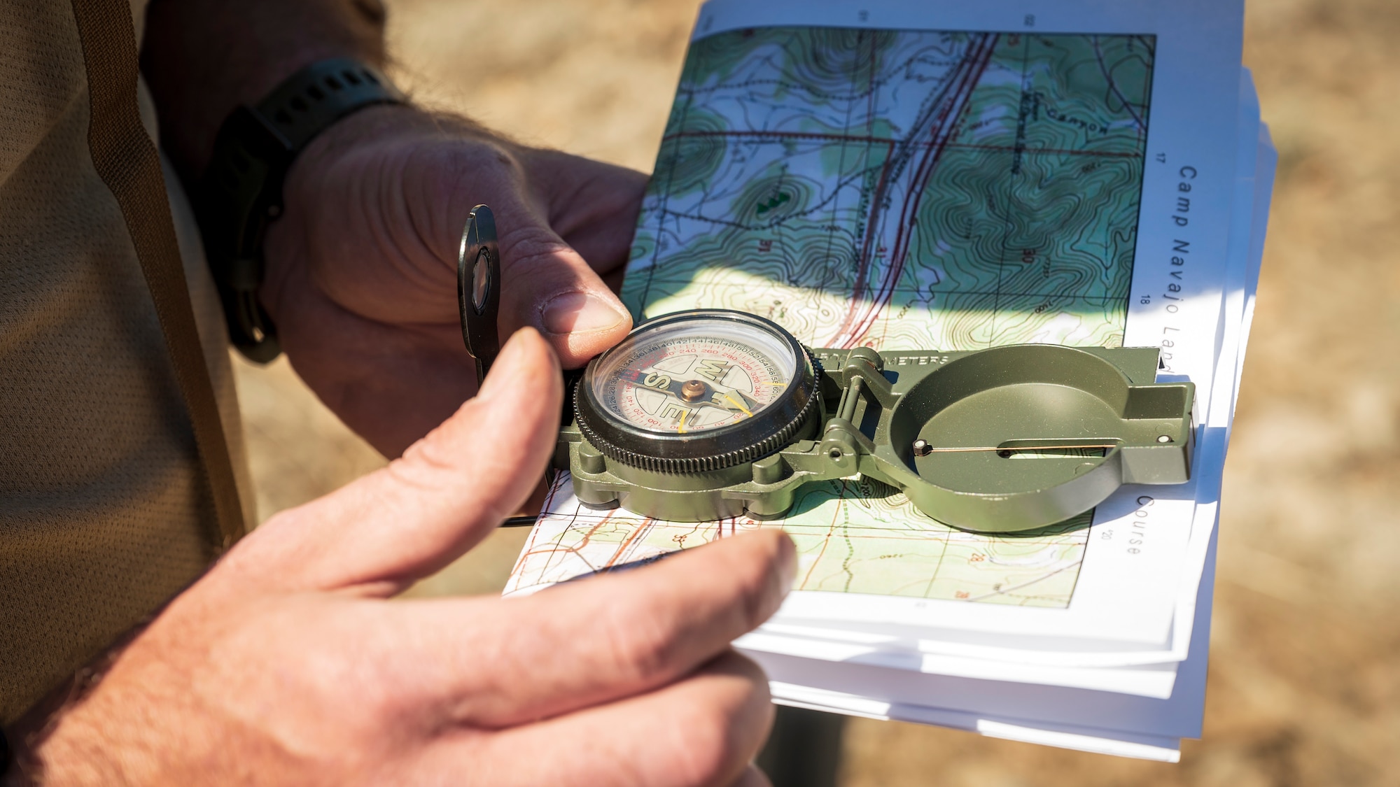 U.S. Air Force Tech. Sgt. Jason, 56th Civil Engineer Squadron Explosive Ordnance Disposal flight technicians, holds a compass and map on a land navigation course at Camp Navajo, Arizona, April 11, 2023.
