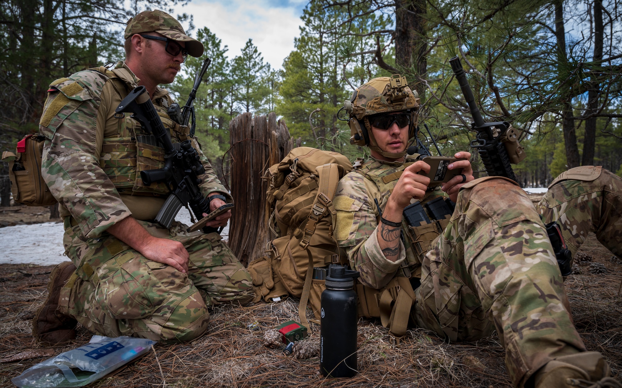 U.S. Air Force Tech. Sgt. Tyler Paul (right) shares coordinates with Staff Sgt. Dustin Drury (left), both 56th Civil Engineer Squadron Explosive Ordnance Disposal flight technicians, during a training scenario at Camp Navajo, Arizona, April 12, 2023.
