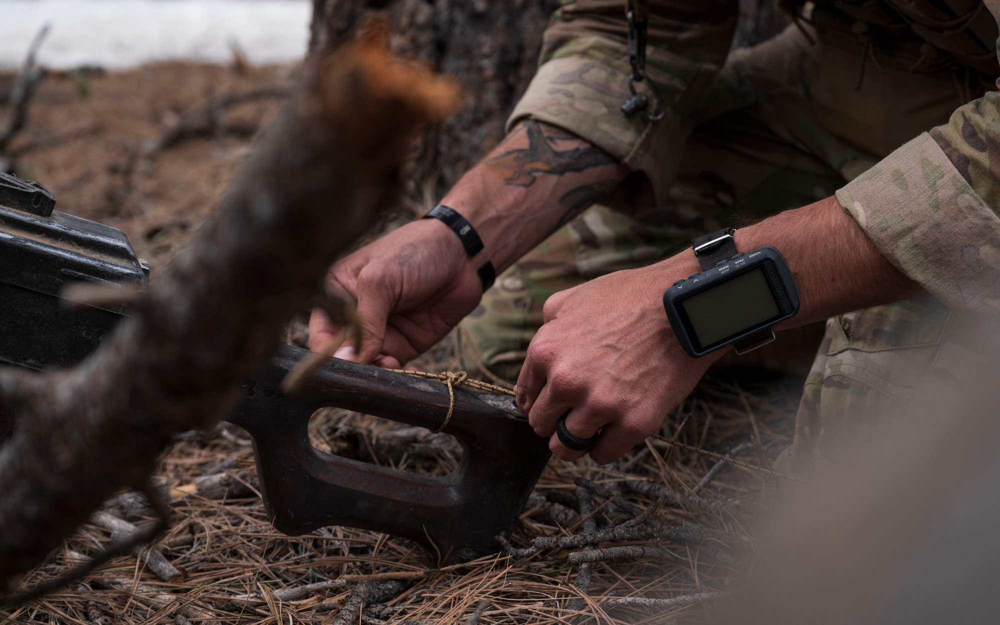 U.S. Air Force Tech. Sgt. Tyler Paul, 56th Civil Engineer Squadron Explosive Ordnance Disposal flight technician, ties a cord around a PK machine gun that was left behind outside a mock village during a training scenario at Camp Navajo, Arizona, April 12, 2023.