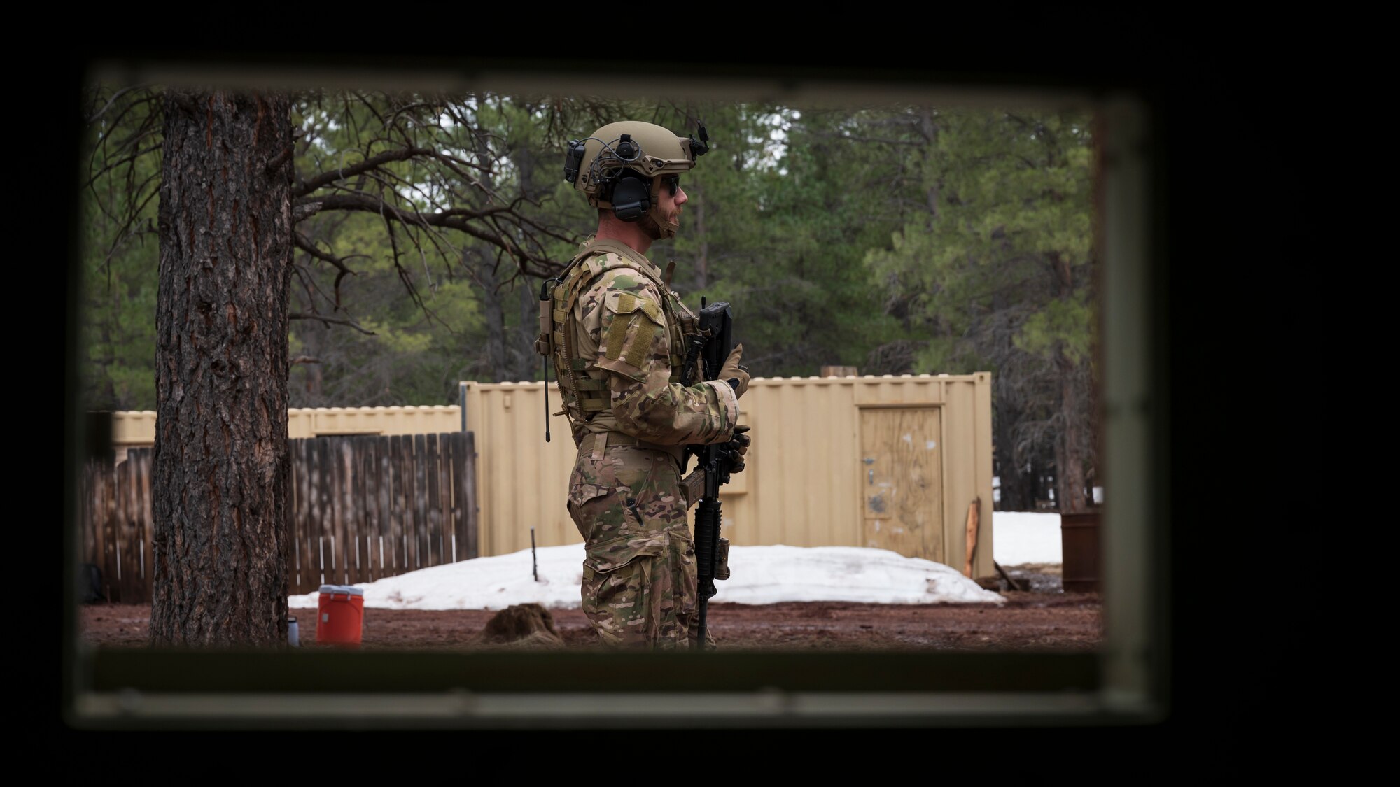 U.S. Air Force Airman 1st Class Jessey Mclain, 56th Civil Engineer Squadron Explosive Ordnance Disposal flight technician, stands watch outside a mock village during a training scenario at Camp Navajo, Arizona, April 12, 2023.