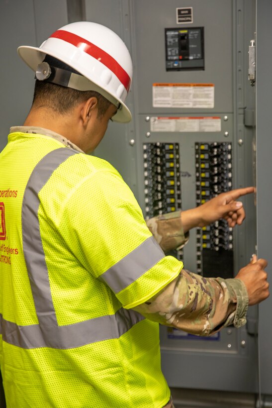 Sgt. Antonio Vargas, with the 249th Engineering Battalion, inspects a fuse panel in the Bayside Community Center.