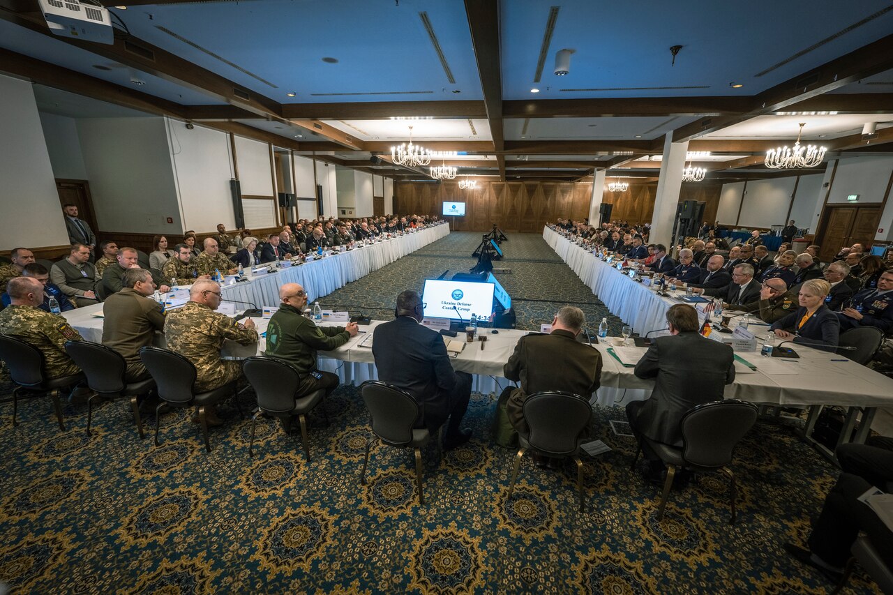 People sit around a large, three-sided table.