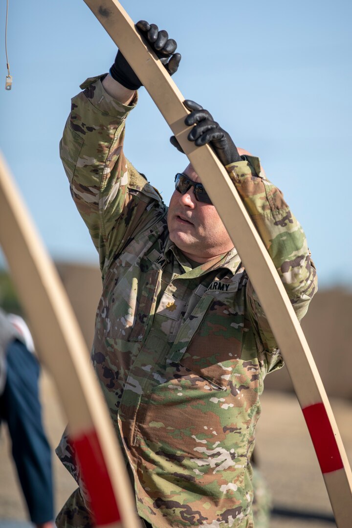 US Army Maj. Michael Hall, a Supply Management Officer with DLA Distribution Army Reserve Element, sets up the frame of an Alaskan Shelter during the DLA Distribution Expeditionary Academy on April 19, at DLA Distribution San Joaquin. Photo by Julian Temblador