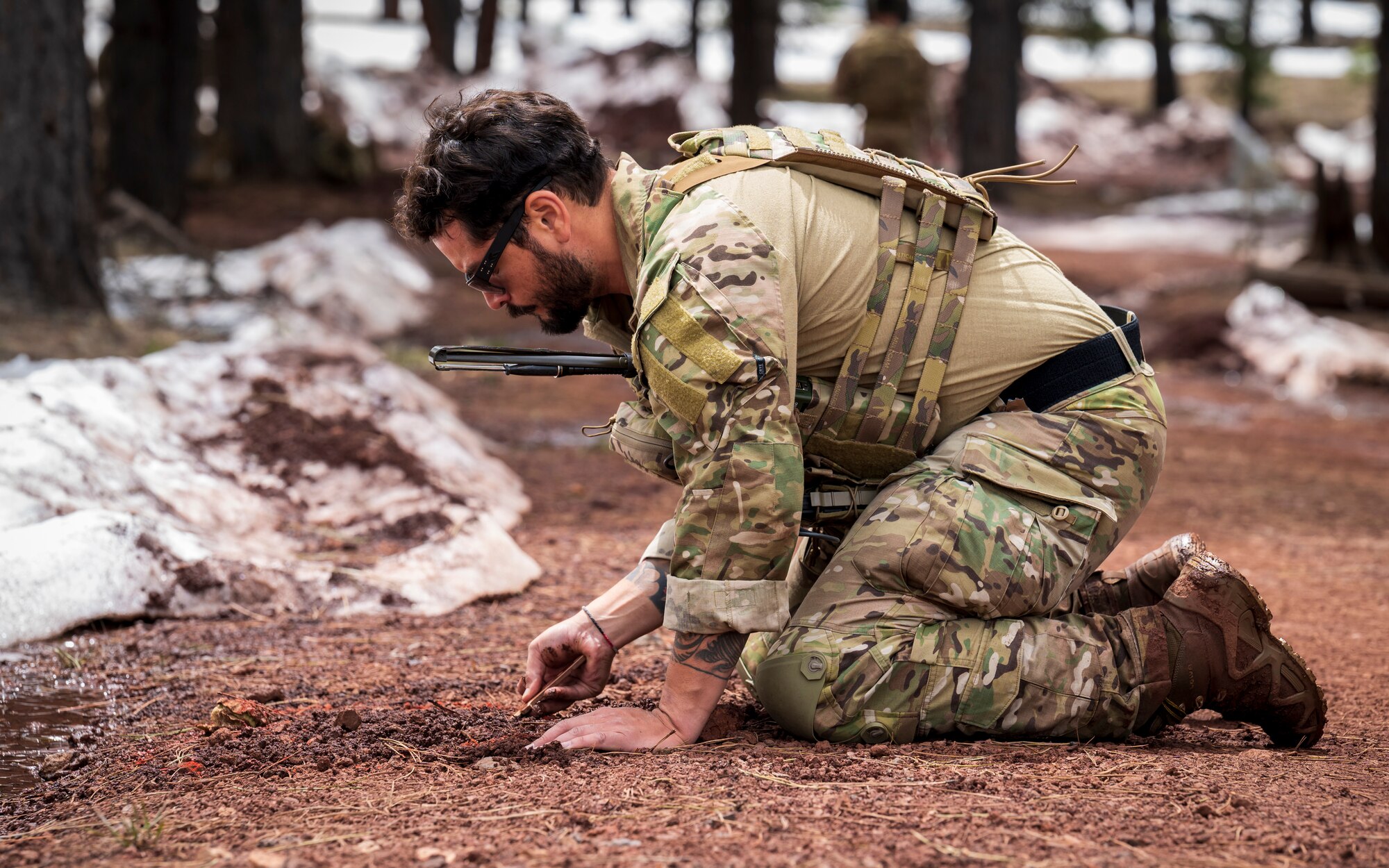 U.S. Air Force Staff Sgt. Antonio Ramirez, 56th Civil Engineer Squadron Explosive Ordnance Disposal flight technician, digs through soil with a non-conductive probe at Camp Navajo, Arizona, April 12, 2023.