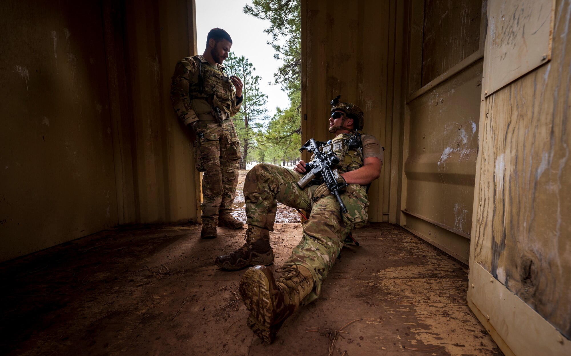 U.S. Air Force Airman 1st Class Jessey Mclain (left), speaks with Senior Airman Gunnar Tokar (right), both 56th Civil Engineer Squadron Explosive Ordnance Disposal flight technicians, inside a storage unit at Camp Navajo, Arizona, April 12, 2023.