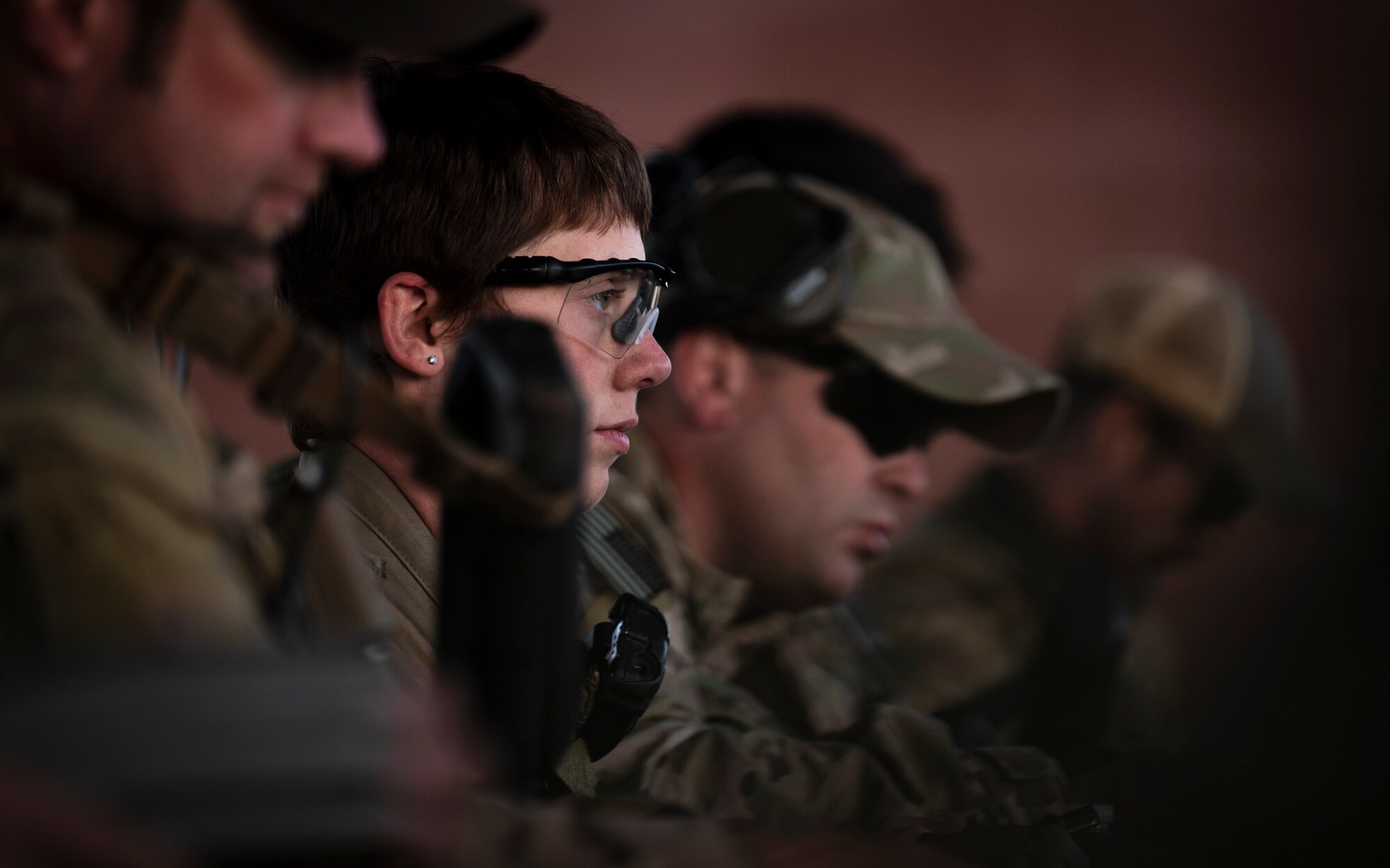 U.S. Air Force Airman First Class Brianna Mclain, 56th Civil Engineer Squadron Explosive Ordnance Disposal flight technician, loads ammunition into an M4 carbine assault rifle magazine alongside other EOD members on a firing range at Camp Navajo, Arizona, April 10, 2023.