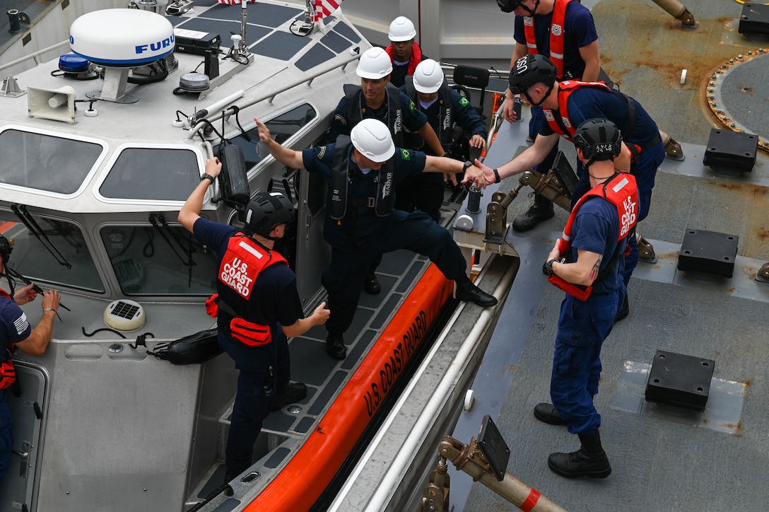 USCGC Stone (WMSL 758) crew members assist Brazilian Navy personnel aboard the Stone during combined exercises in the Southern Atlantic Ocean, March 6, 2023. Stone is on a scheduled multi-mission deployment in the South Atlantic Ocean to counter illicit maritime activities and strengthen relationships for maritime sovereignty throughout the region. (U.S. Coast Guard photo by Petty Officer 3rd Class Riley Perkofski)
