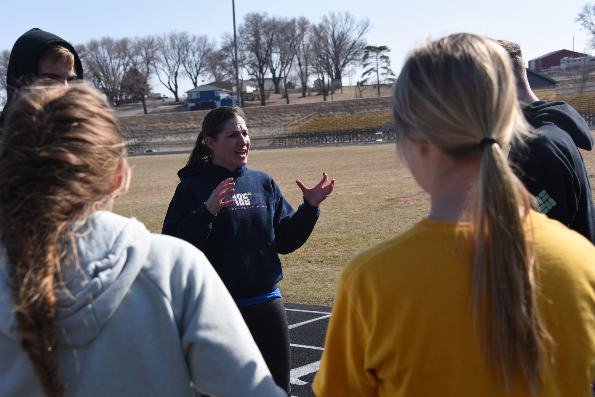 Lt. Col. Jennifer Carlson speaks with her track team.