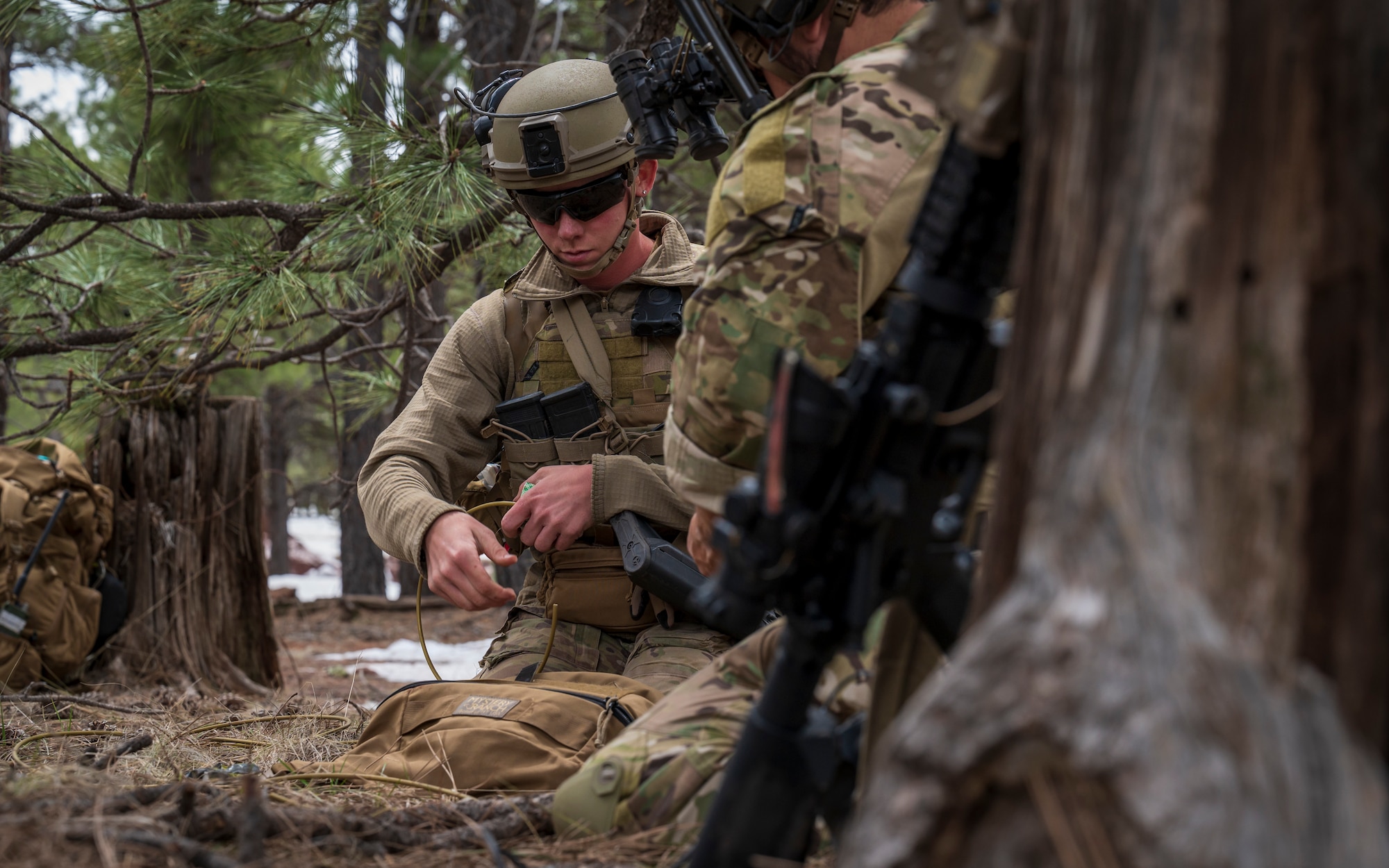 U.S. Air Force Airman 1st Class Brianna Mclain, 56th Civil Engineer Squadron Explosive Ordnance Disposal flight technician, cuts cable for a C4 charge at Camp Navajo, Arizona, April 12, 2023.