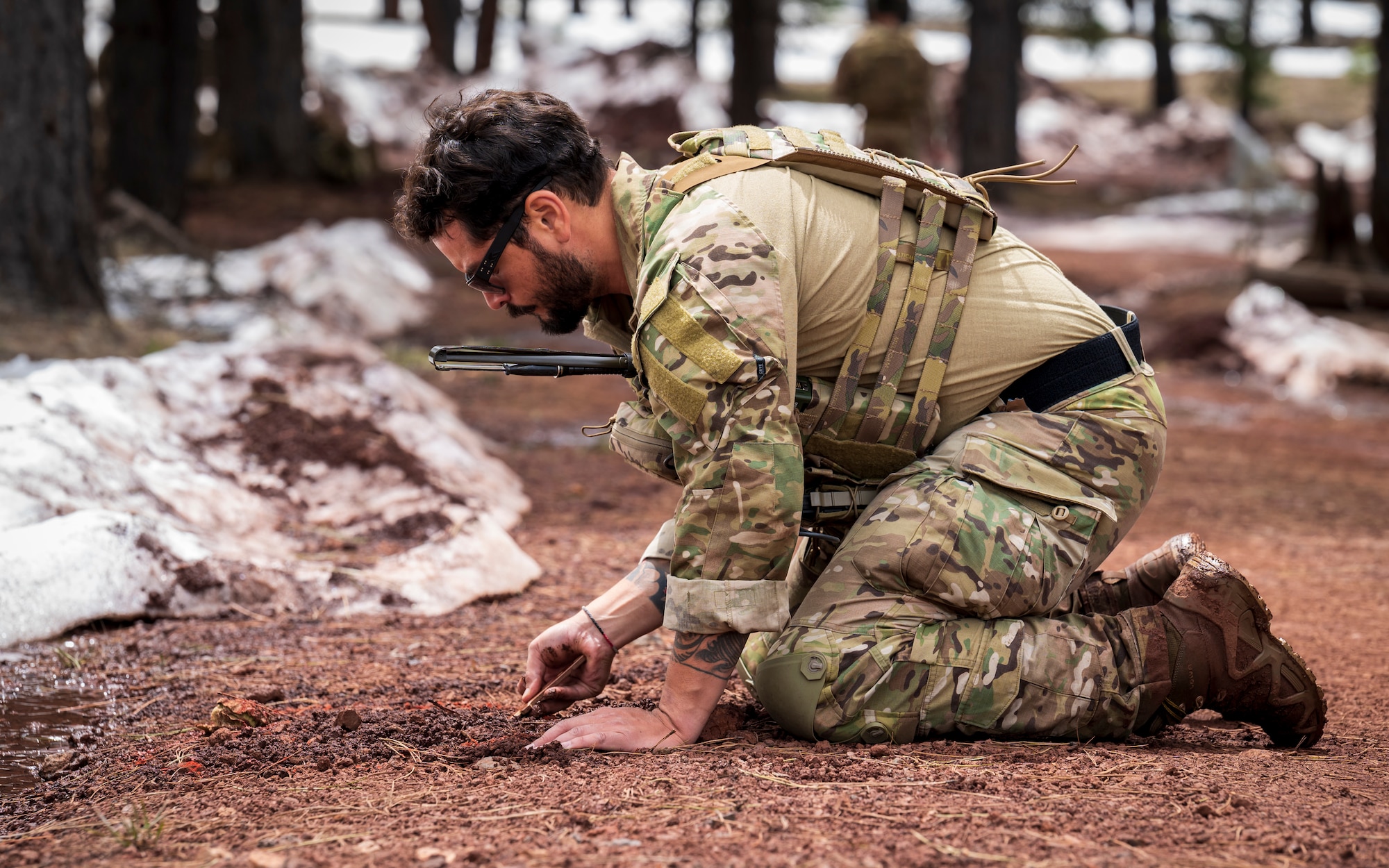 U.S. Air Force Staff Sgt. Antonio Ramirez, 56th Civil Engineer Squadron Explosive Ordnance Disposal flight technician, digs through soil with a non-conductive probe at Camp Navajo, Arizona, April 12, 2023.