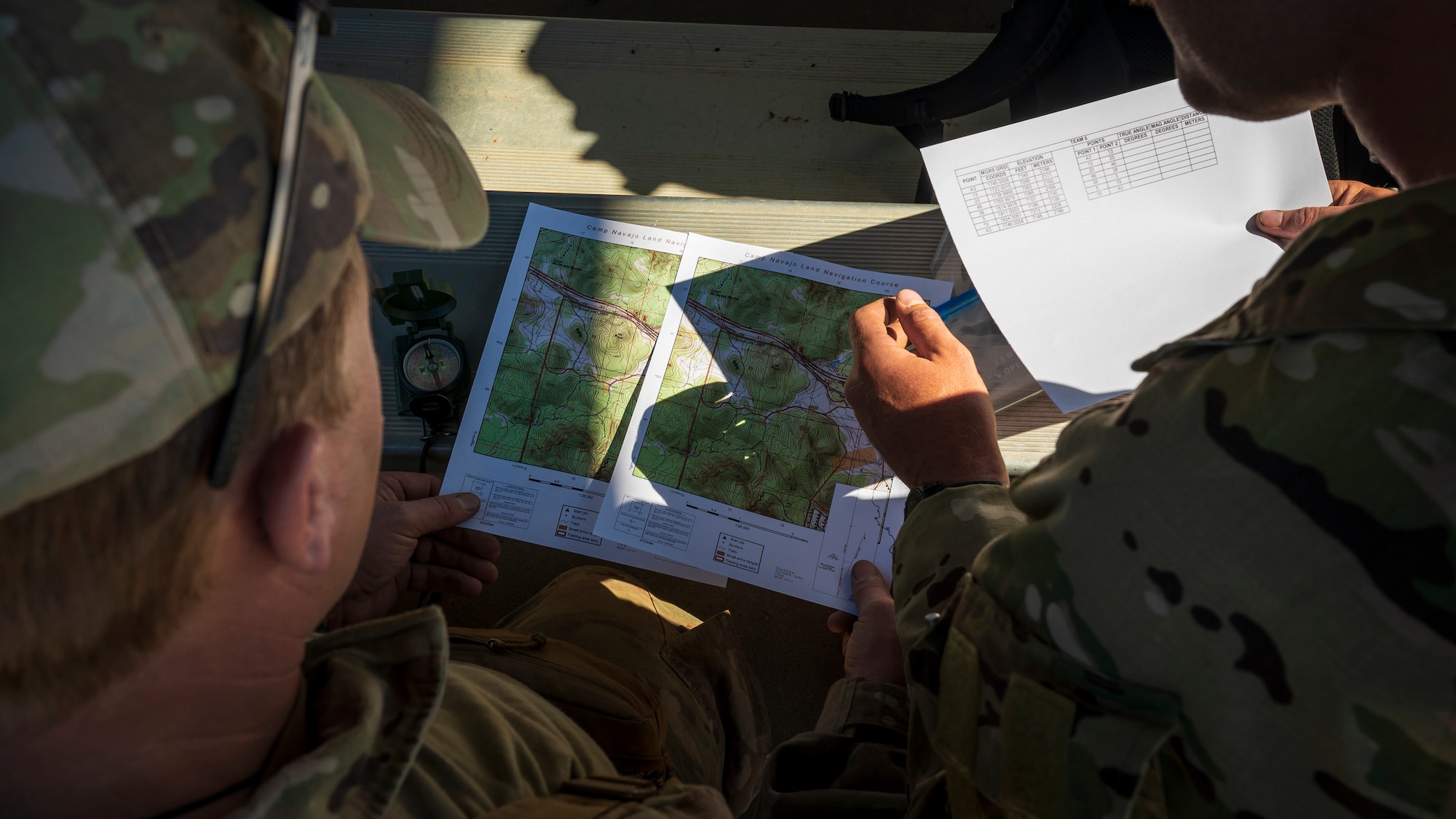 U.S. Air Force Senior Airman Steven Webb (left) and Staff Sgt. Dustin Drury, 56th Civil Engineer Squadron Explosive Ordnance Disposal flight technicians, review maps and coordinates at Camp Navajo, Arizona, April 11, 2023.