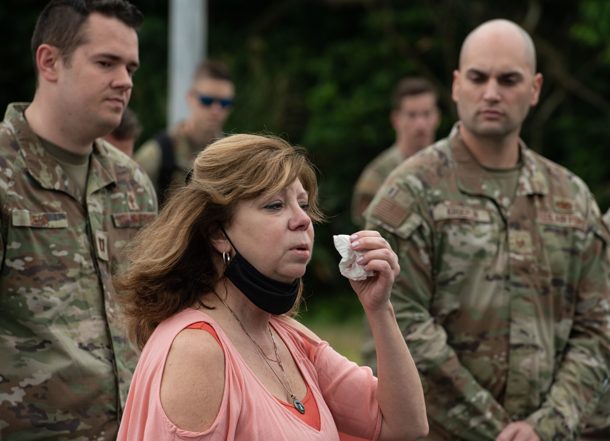 A woman wipes away tears with a tissue.