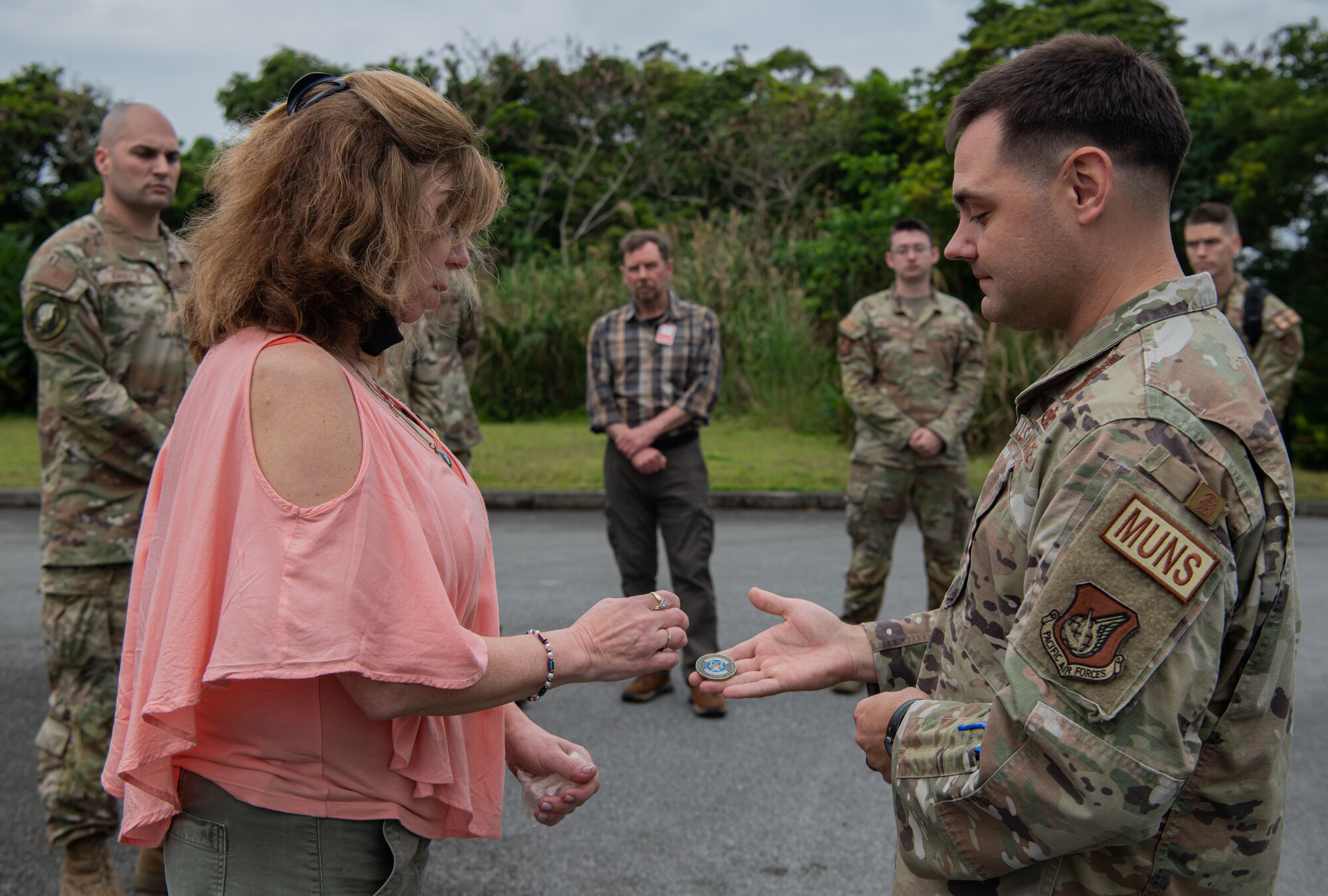 A man hands a woman a coin.