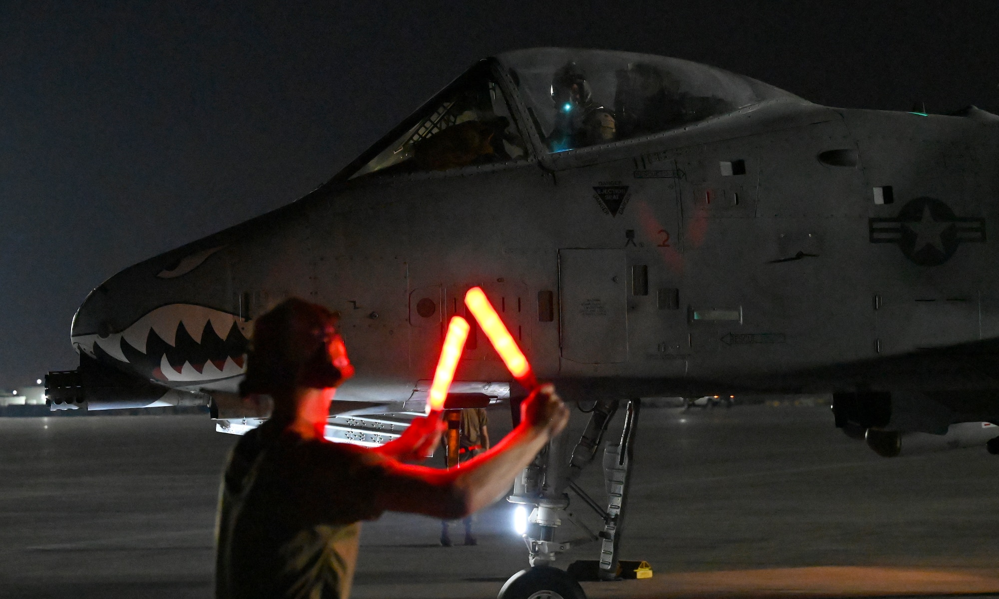 U.S. Air Force Airman 1st Class Dylan Prusso, 75th Expeditionary Fighter Generation Squadron crew chief, marshalls a 75th Expeditionary Fighter Squadron A-10 Thunderbolt II for a combat sortie in the U.S. Central Command area of responsibility at Al Dhafra Air Base, United Arab Emirates, April 20, 2022. The deployment of A-10s in the region provides additional capability in the Middle East alongside fighter aircraft. This deployment ensures close air support specialists are able to build upon their skills in environments outside of the United States and ensure combat operations remain sharp across the force. (U.S. Air Force photo by Tech. Sgt. Alex Fox Echols III)