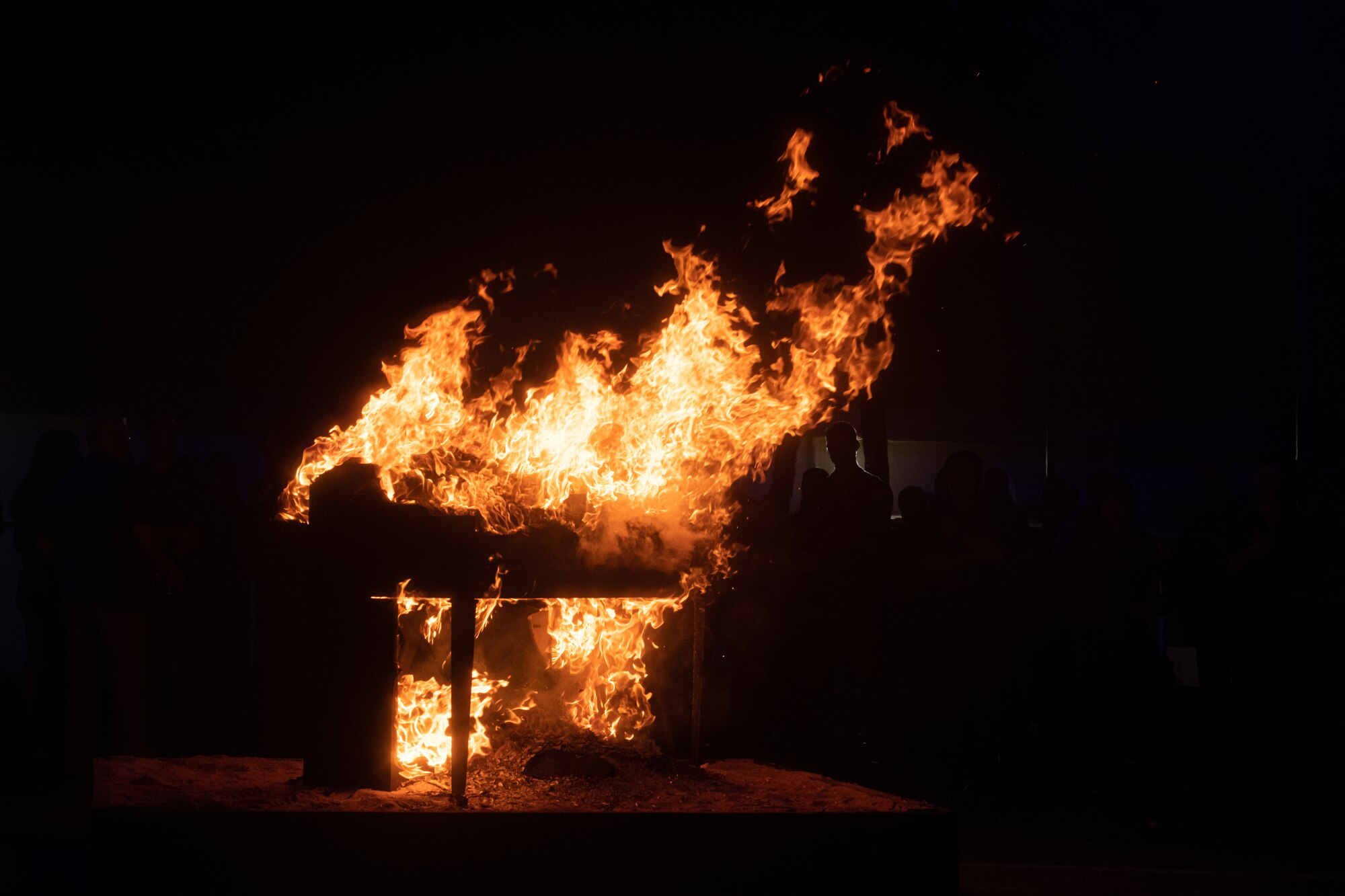 A piano burns in the darkness.