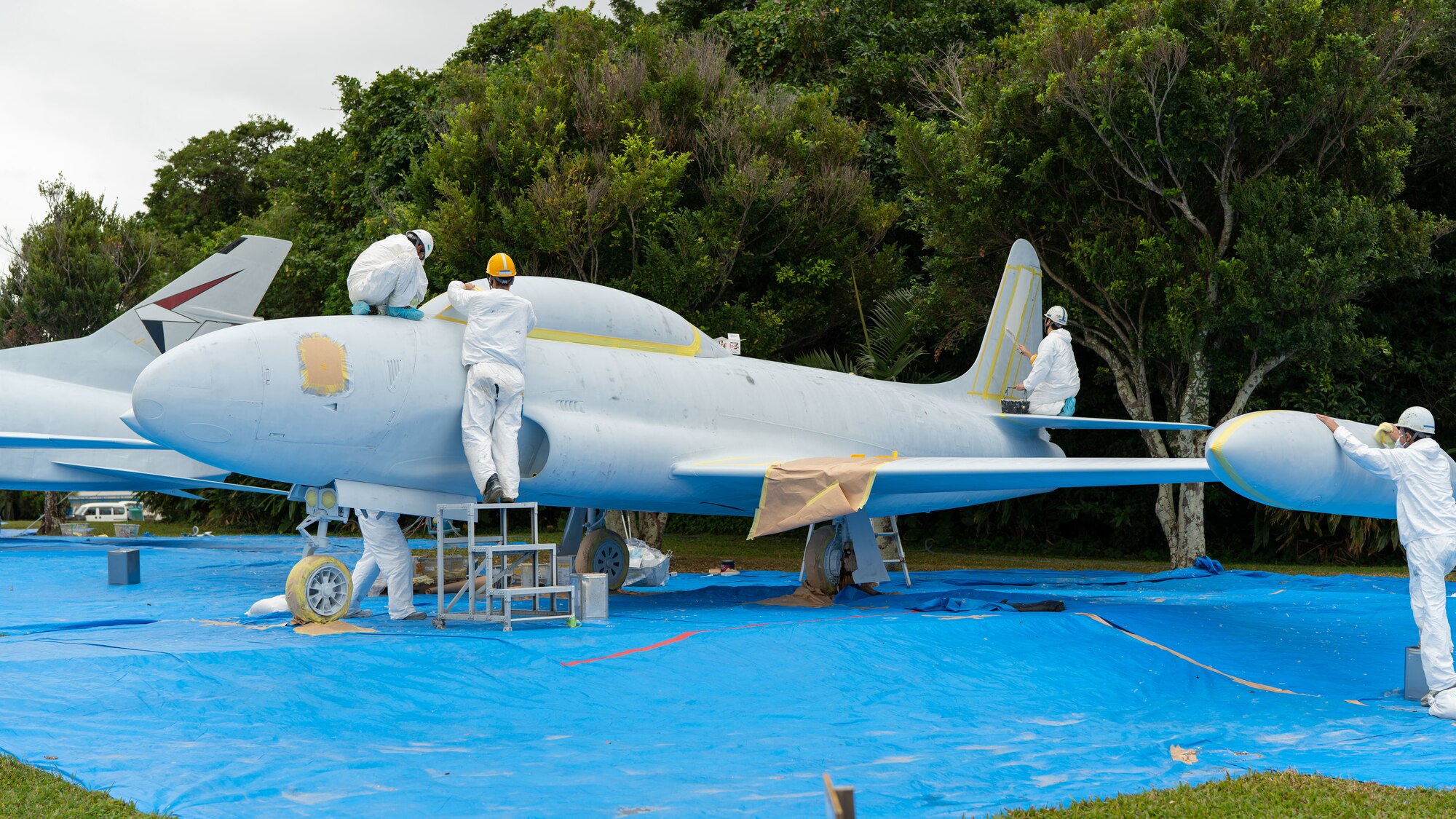 Painters restore a jet.