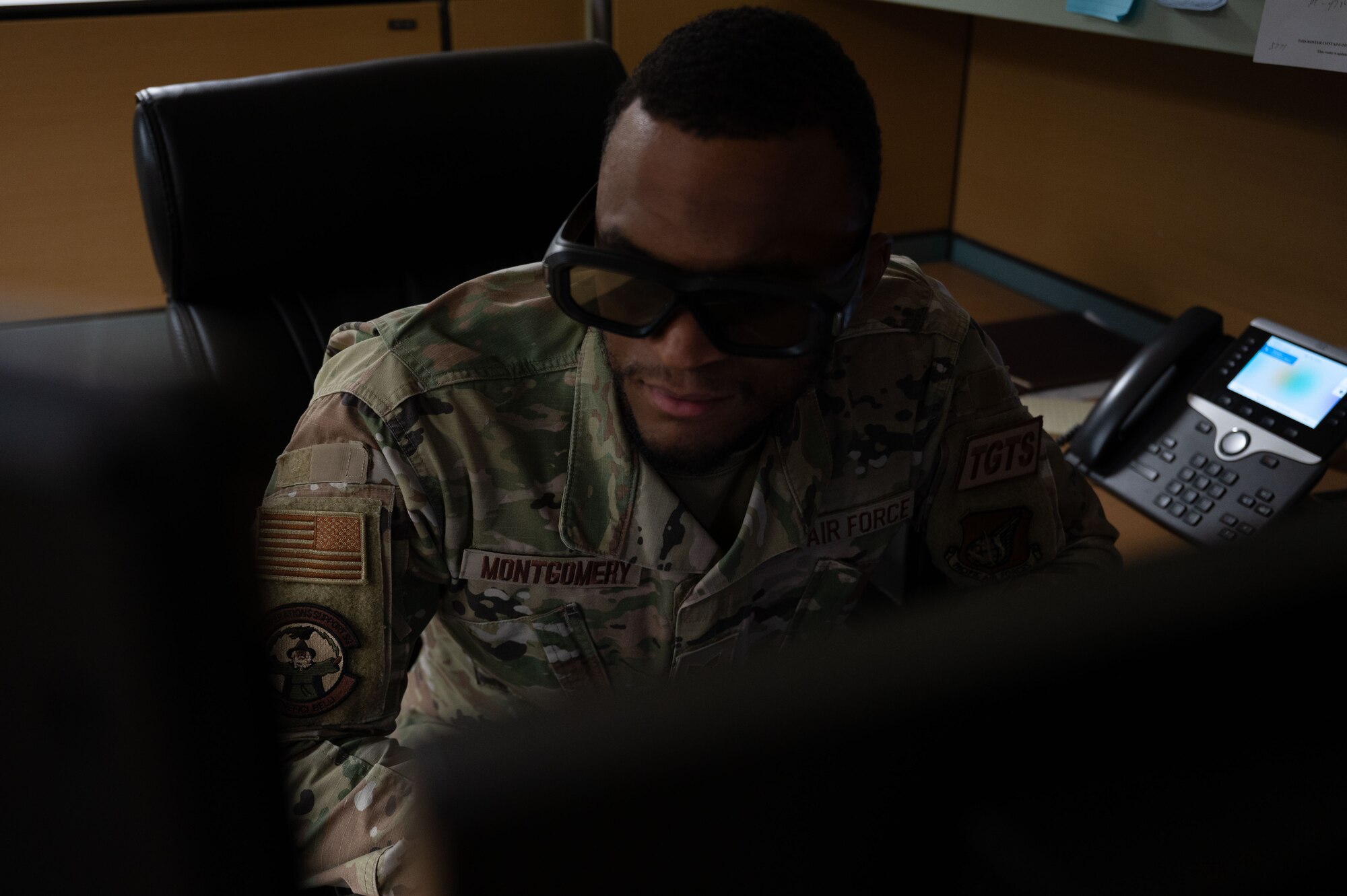 Senior Airman Bryan Montgomery, 8th Operations Support Squadron targeting analyst works on a computer wearing 3-D glasses on Kunsan Air Base, Republic of Korea, April 24, 2023. As a targeting analyst, the 3-D glasses help him see the field in three dimensions, allowing him to better calculate targets, distances and destinations. (U.S. Air Force photo by Tech. Sgt. Timothy Dischinat).